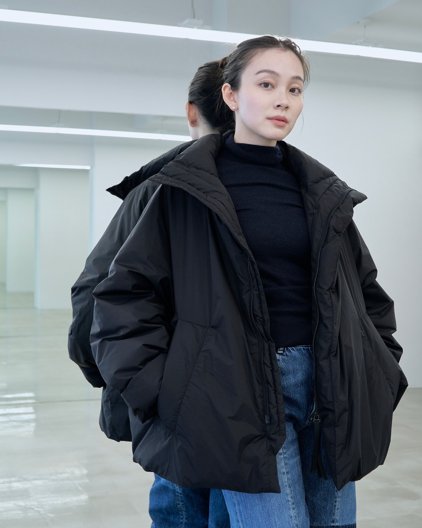 テアトラのダウンアウター「ミュートスコープ S/S」を着用した女性モデル