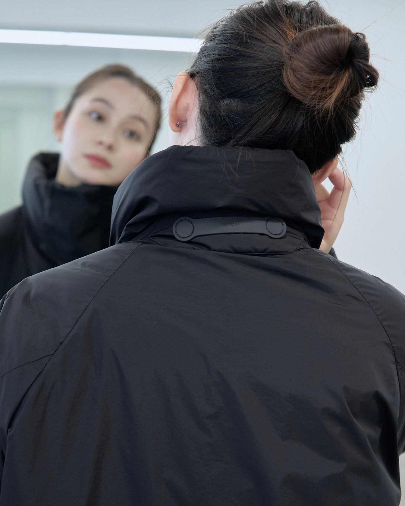 テアトラのダウンアウター「ミュートスコープ S/S」を着用した女性モデル