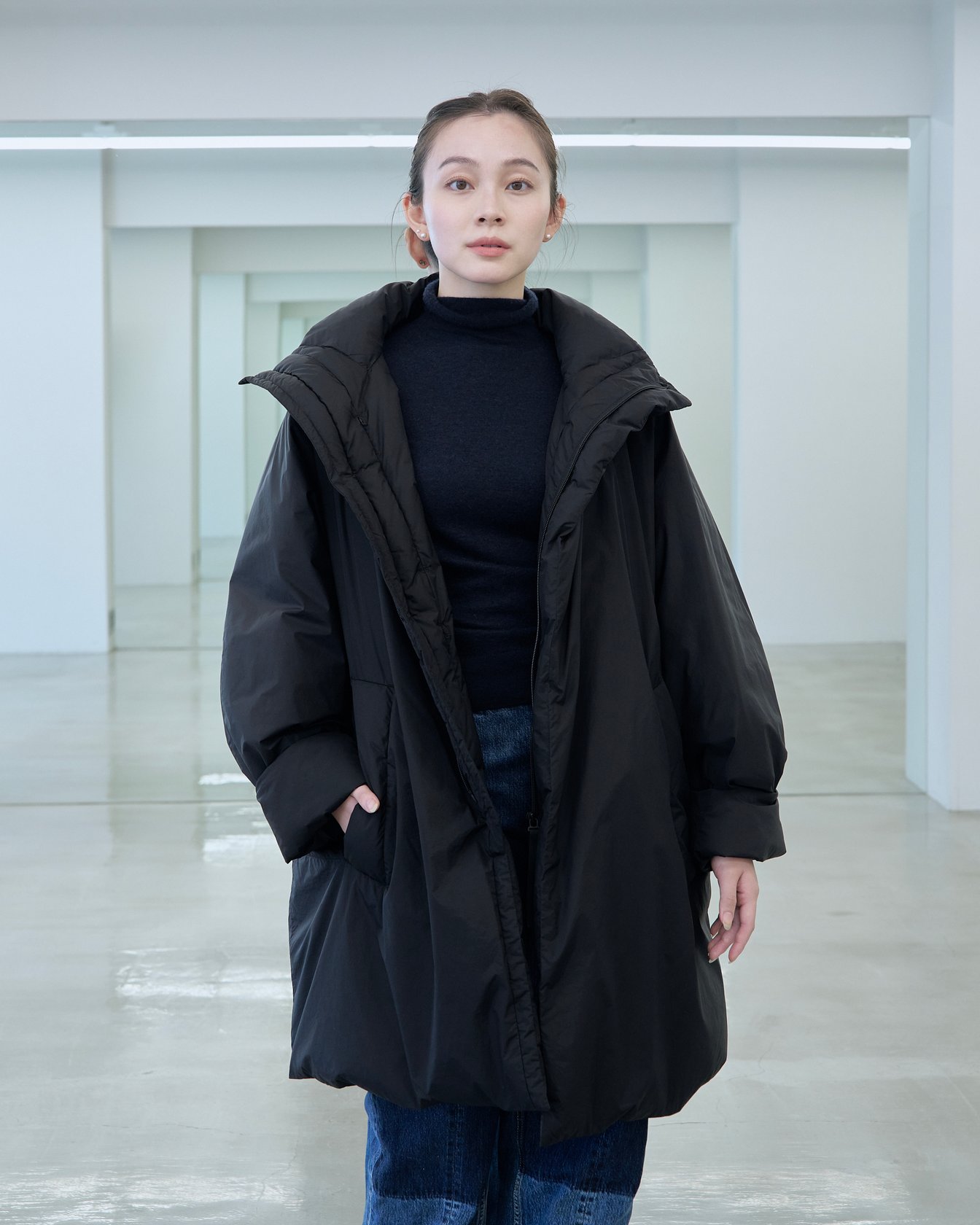 テアトラのダウンアウター「ミュートスコープ S/S」を着用した女性モデル