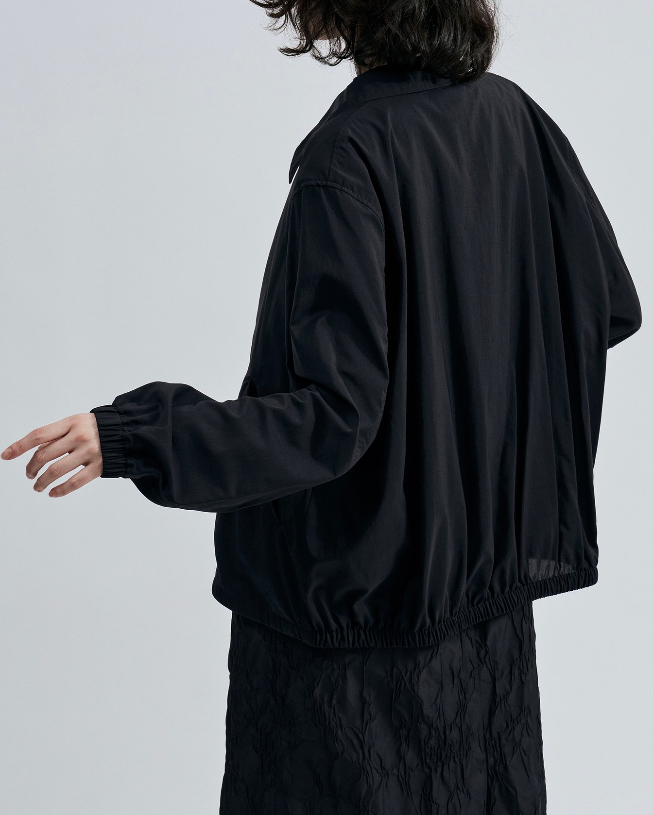 「エイトン」のナイロンジャケットを着たモデル