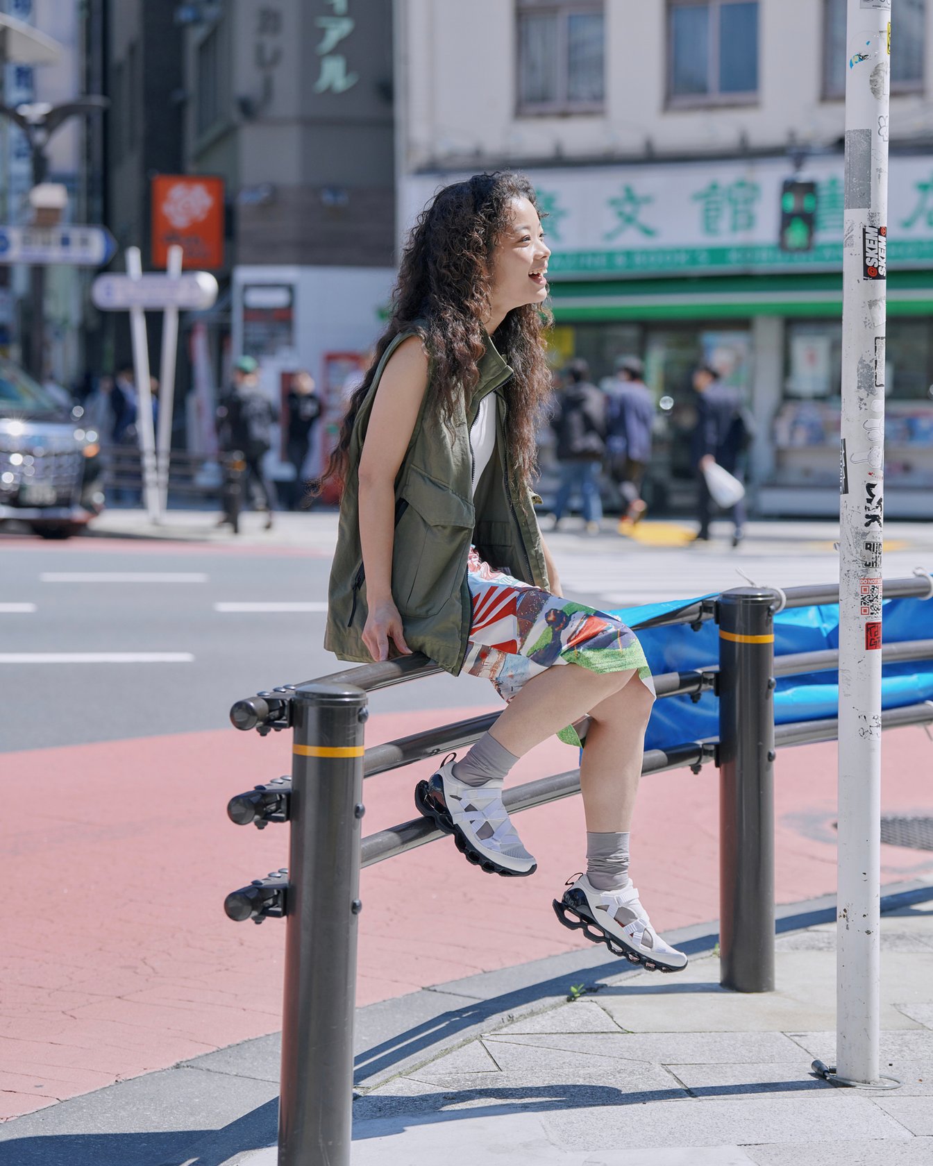 ガードレールに腰掛けた女性