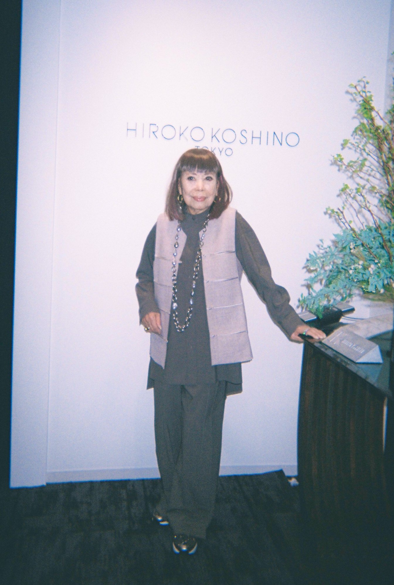 ブランドのロゴの前に立つコシノヒロコさん