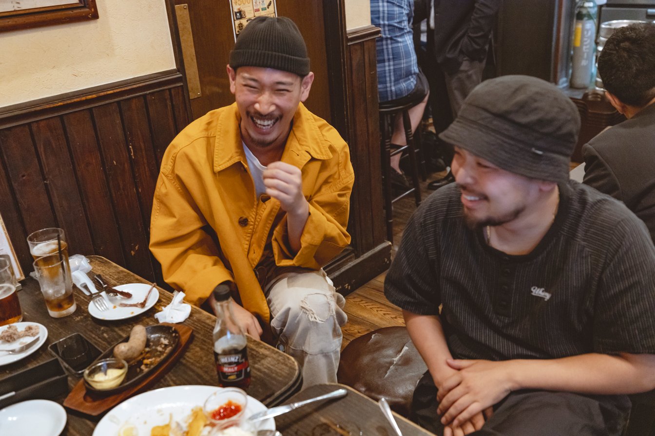 黄色いジャケットを着た男性と黒いTシャツを着た男性
