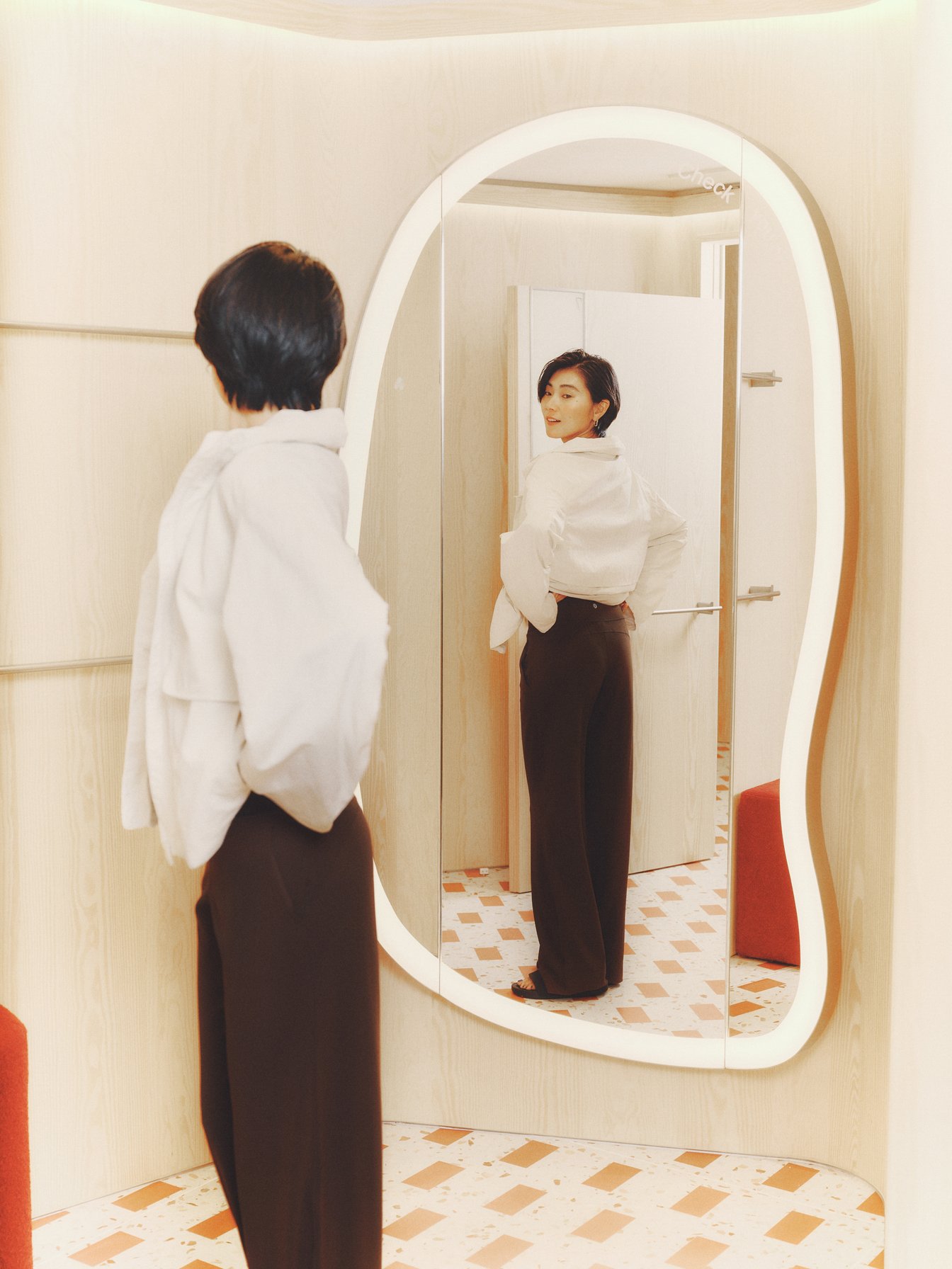 ブラウンのパンツと白いジャケットを着たモデル