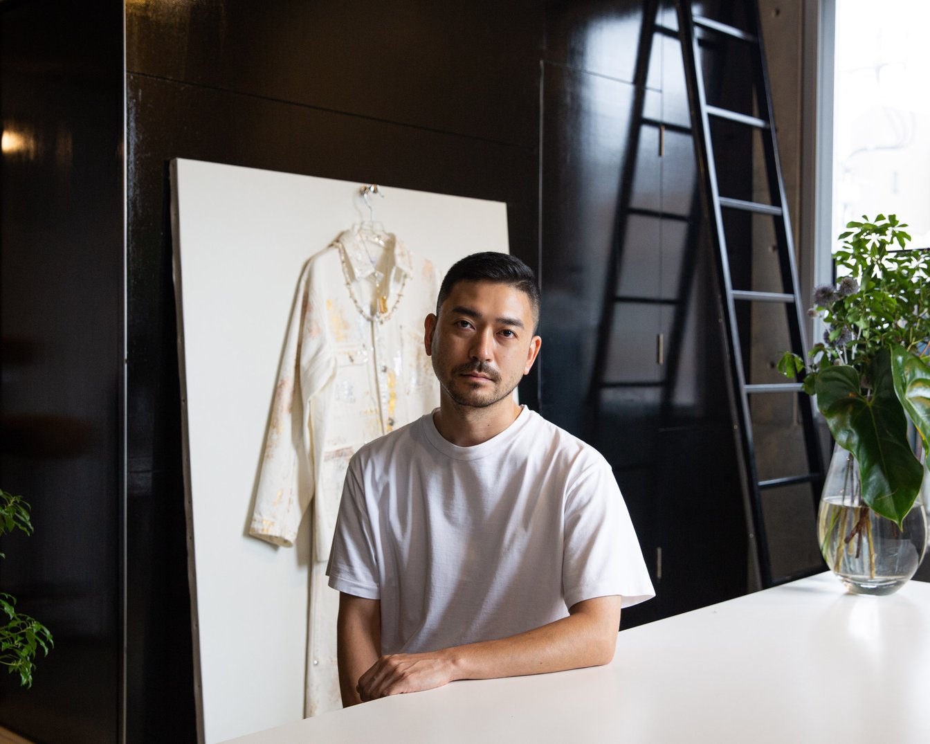 アトリエの机に手を置く男性ディレクター