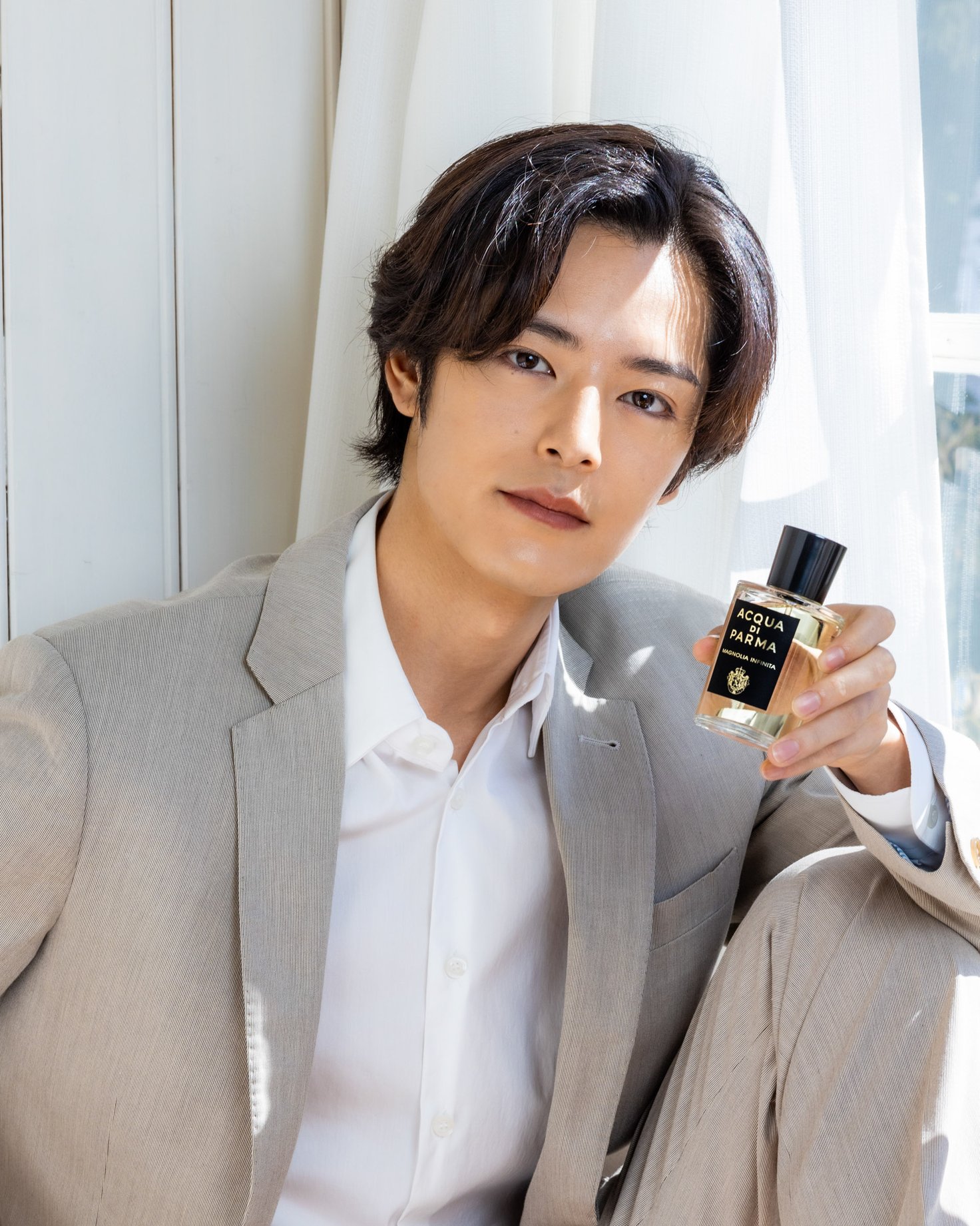 左手に香水を持った男性