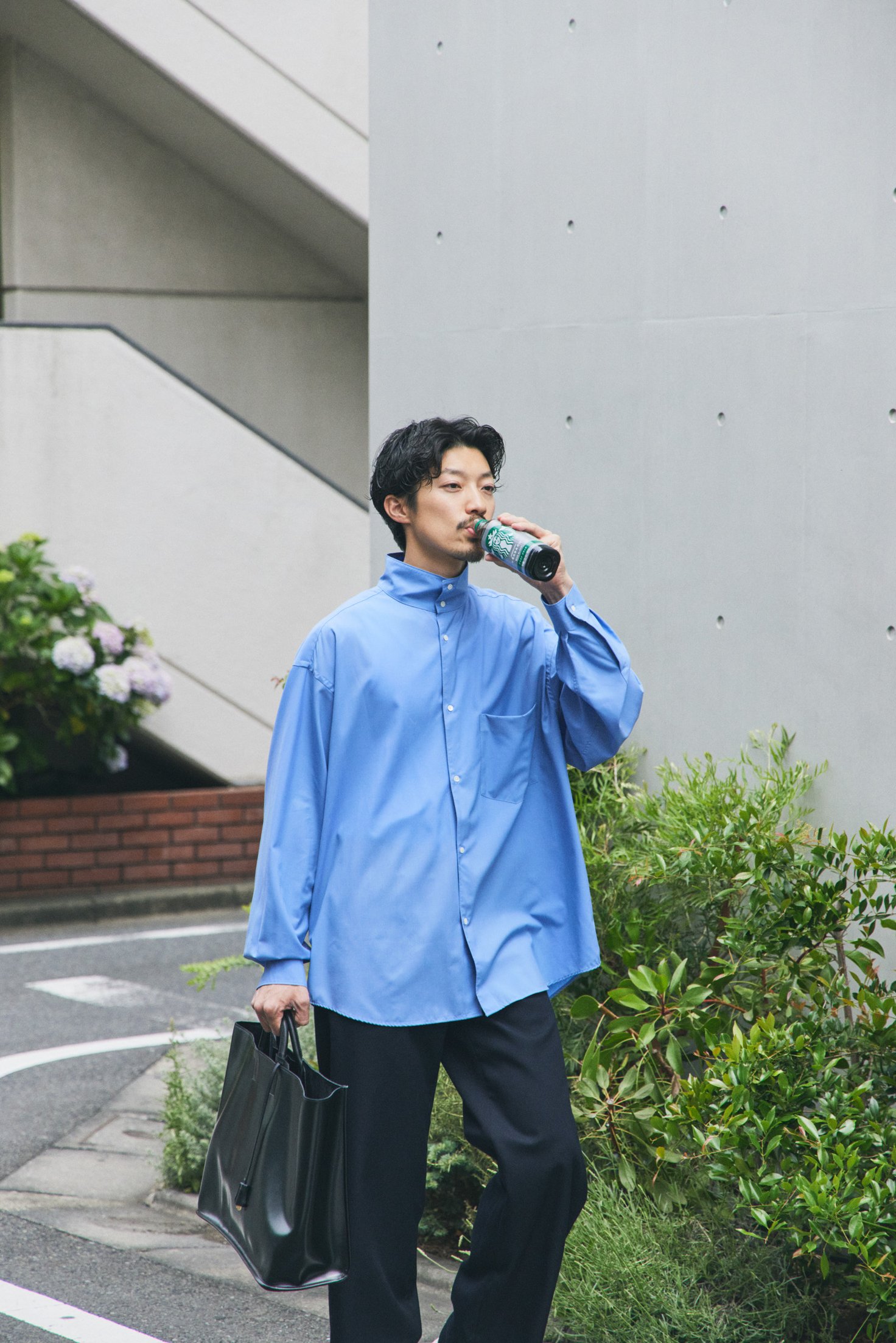 スターバックスのボトルを手に持った男性