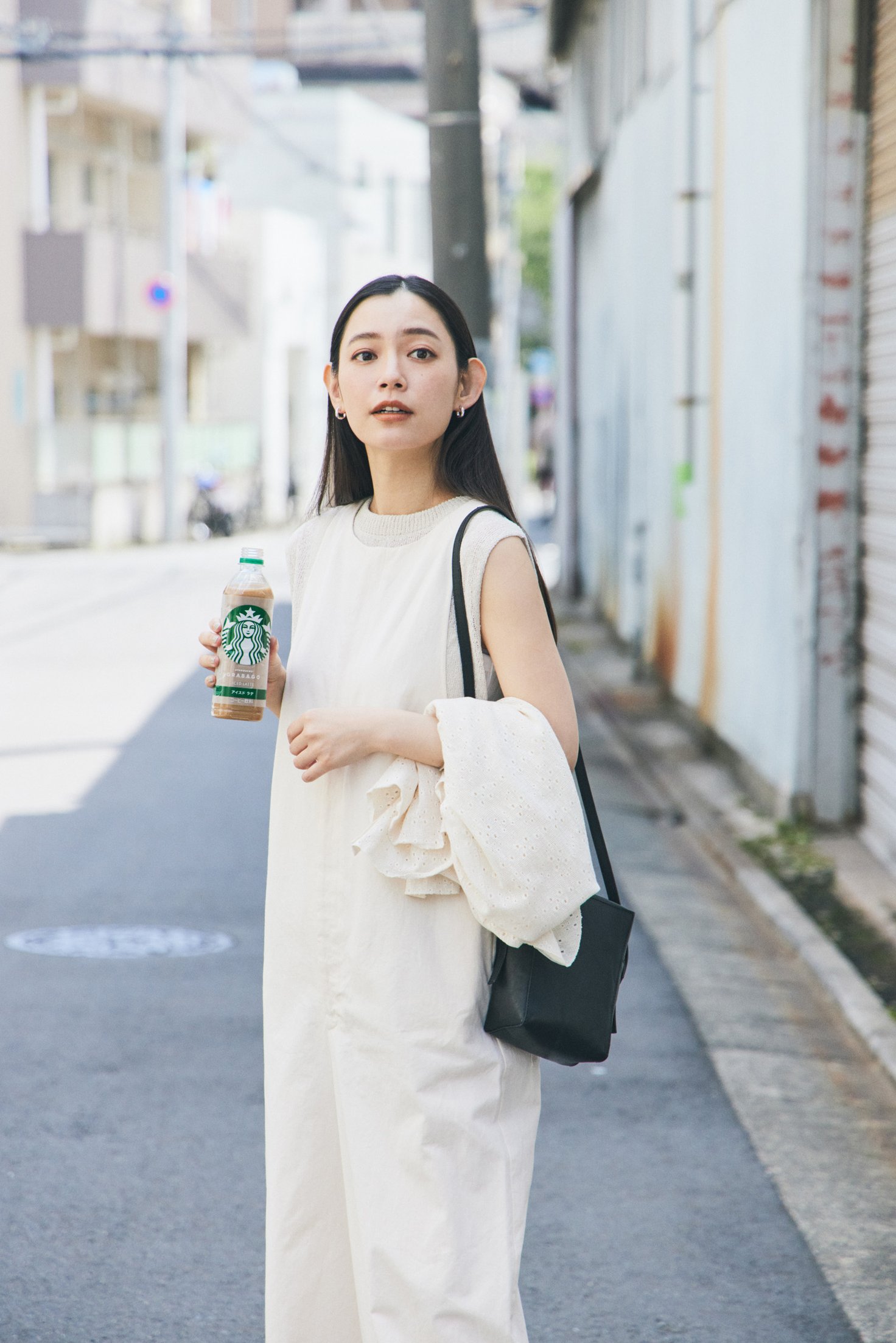 スターバックスのボトルを手に持った女性