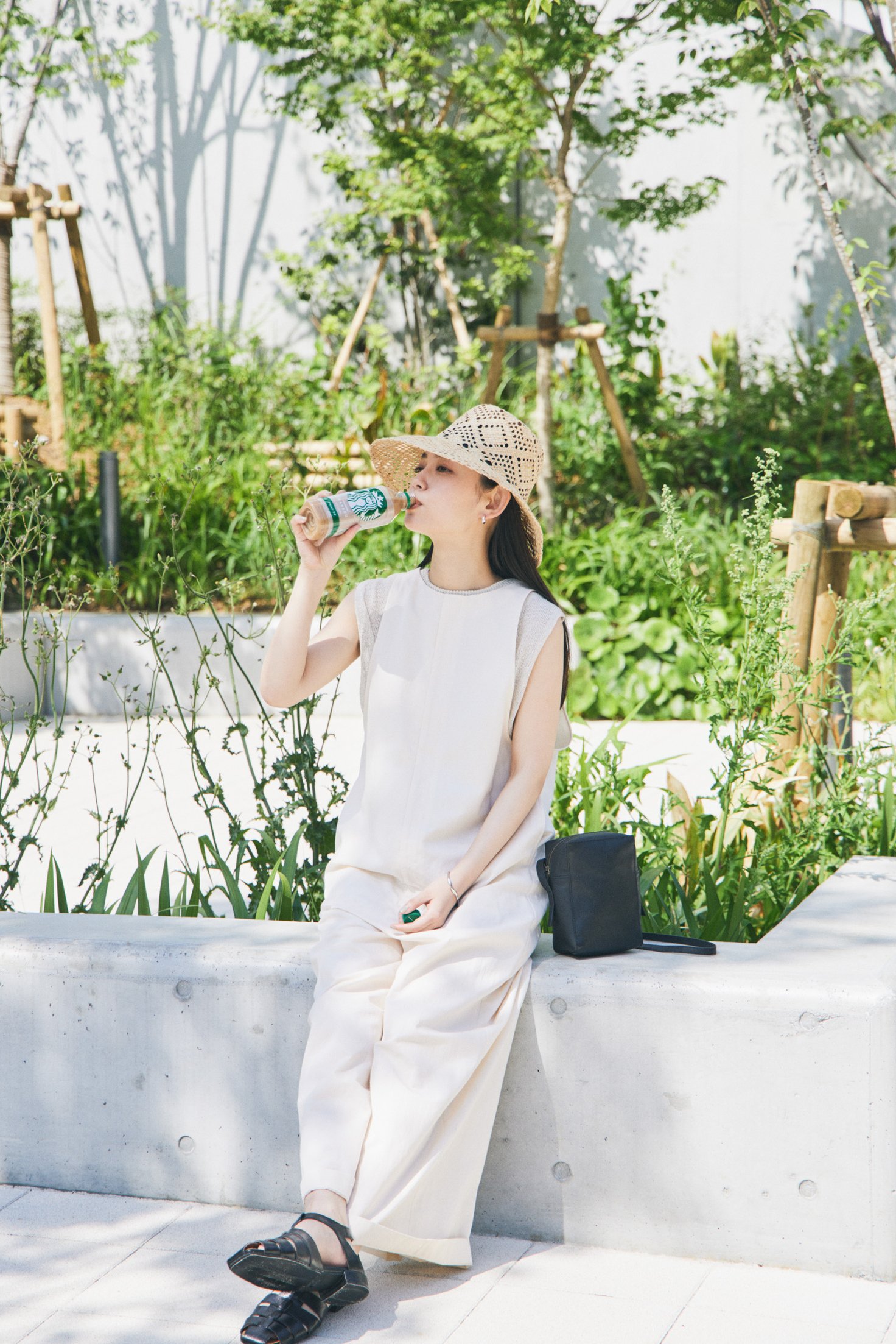 公園でスターバックスを飲む女性