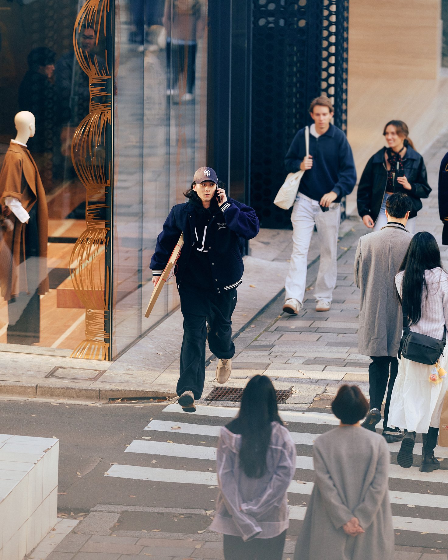 ポスターを抱えて街中を走る栁俊太郎