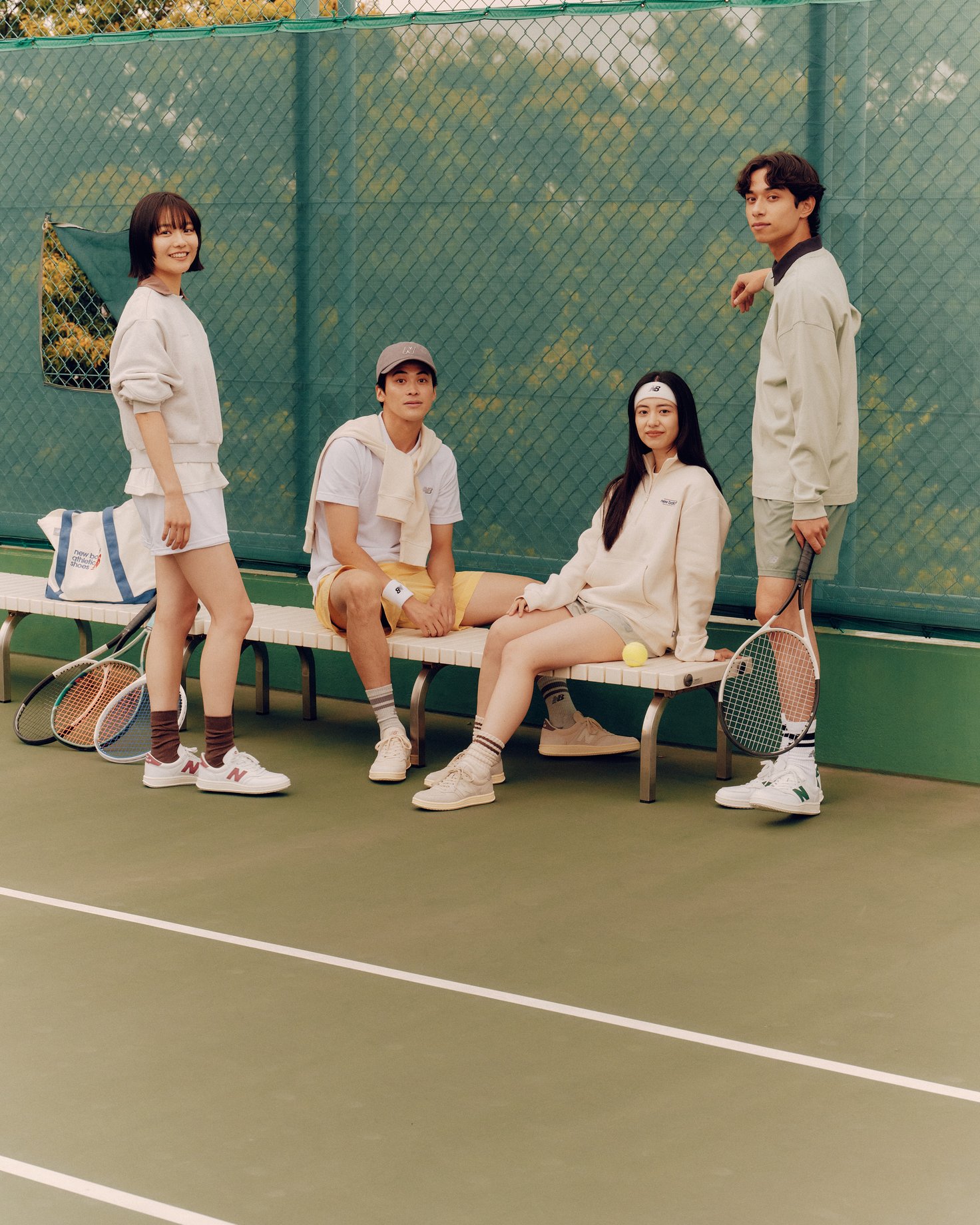 テニスコートで談笑するモデル4人