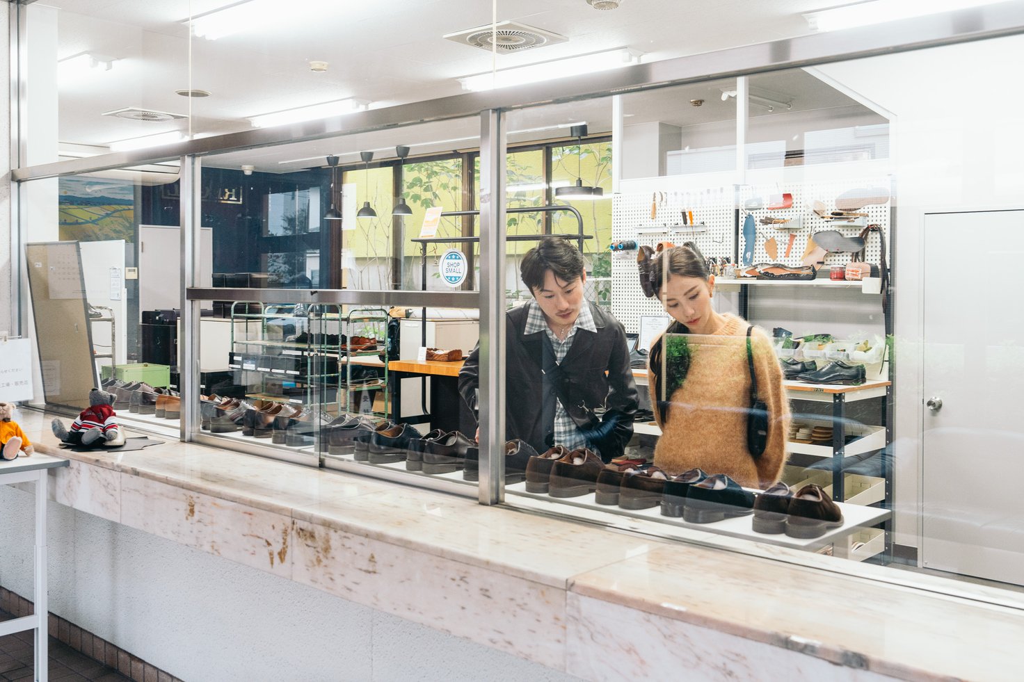 東立製靴の店内で革靴を見る2人