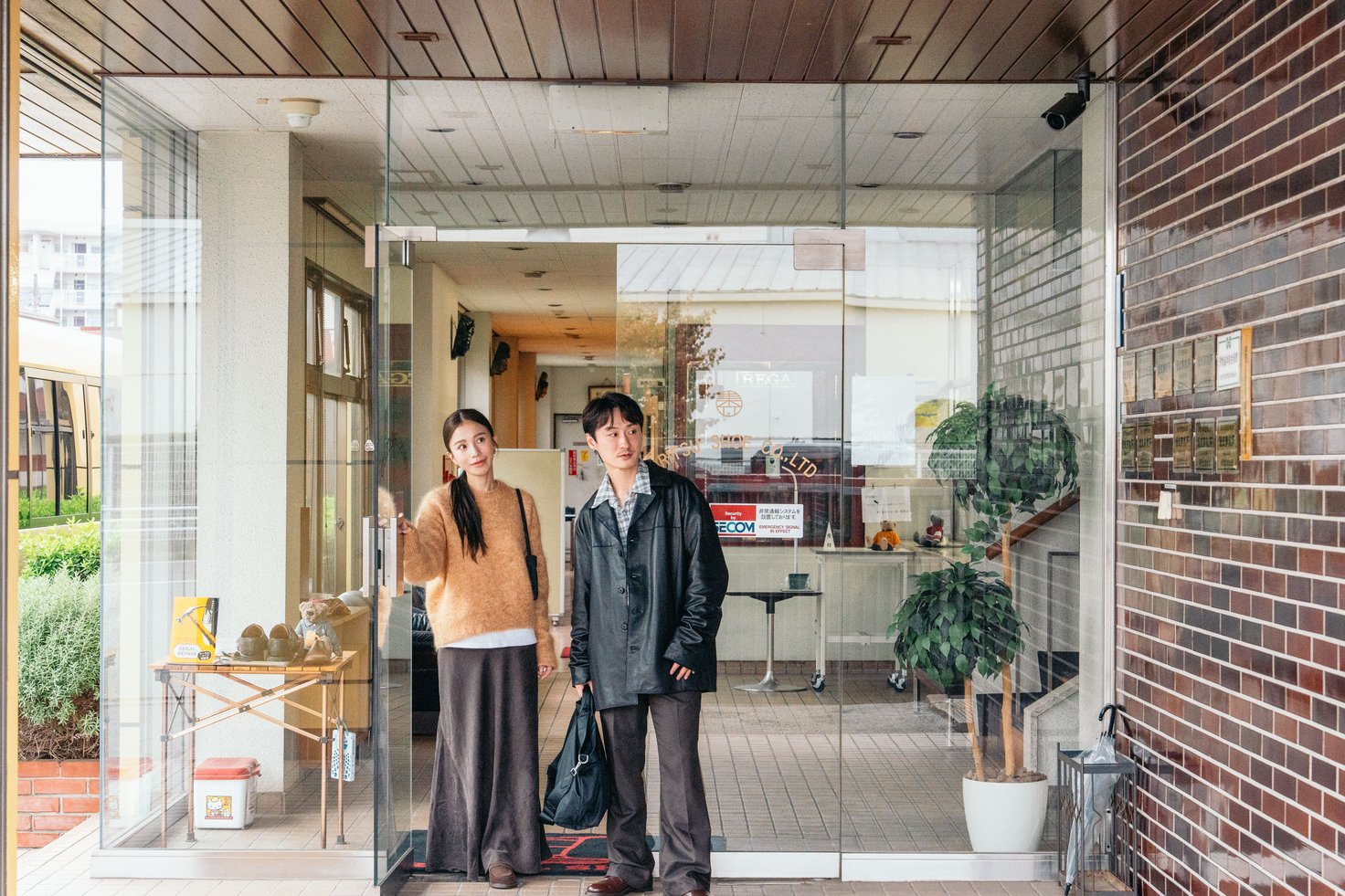 東立製靴の工場から出てくる2人