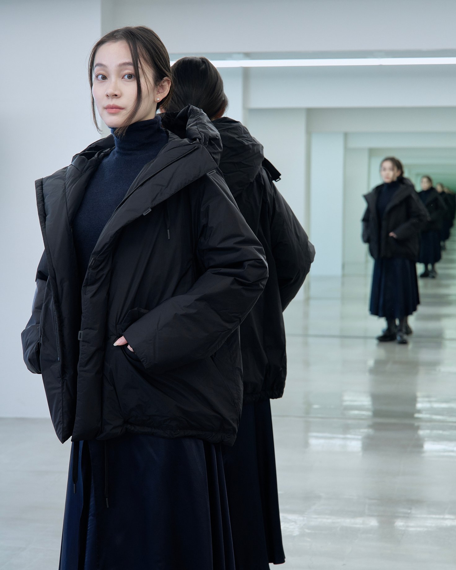 テアトラのダウンアウター「スーベニアハンター」を着用した女性モデル