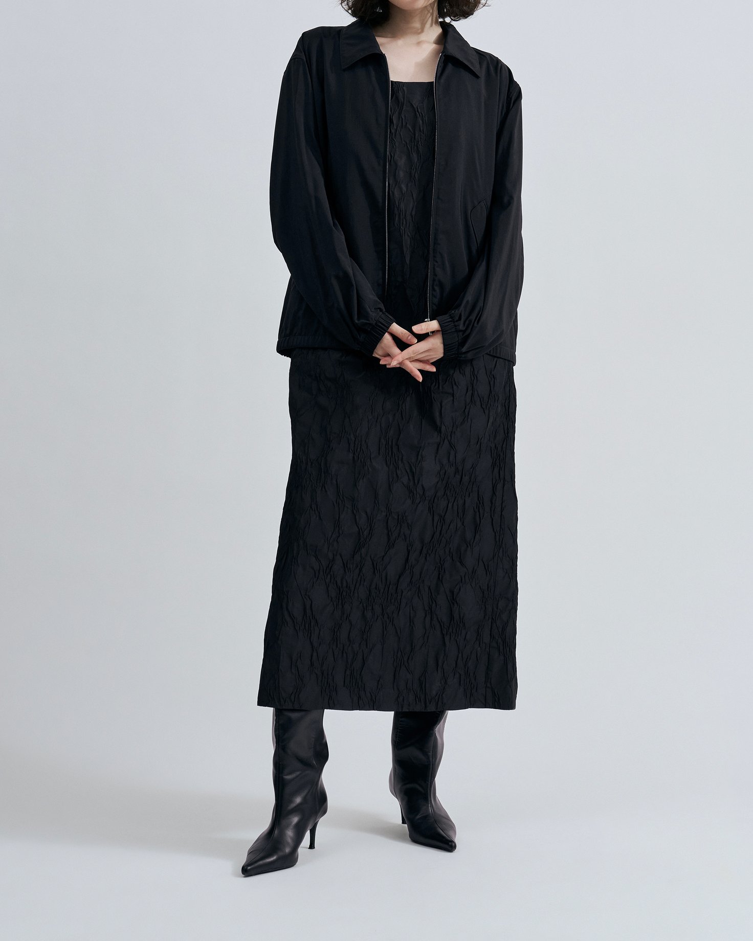 「エイトン」のナイロンジャケットを着たモデル