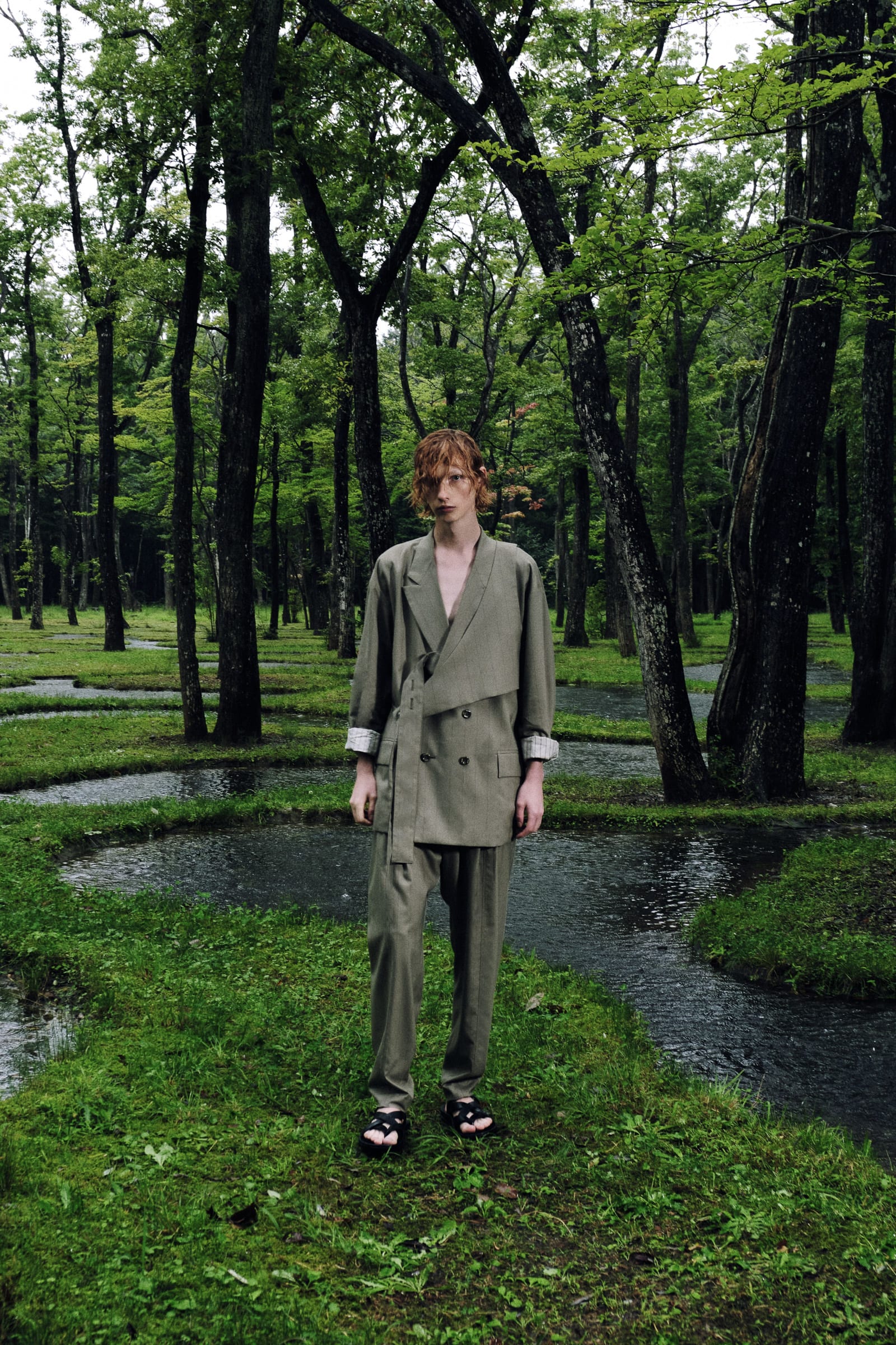 モスグリーンのセットアップを着用した女性モデル