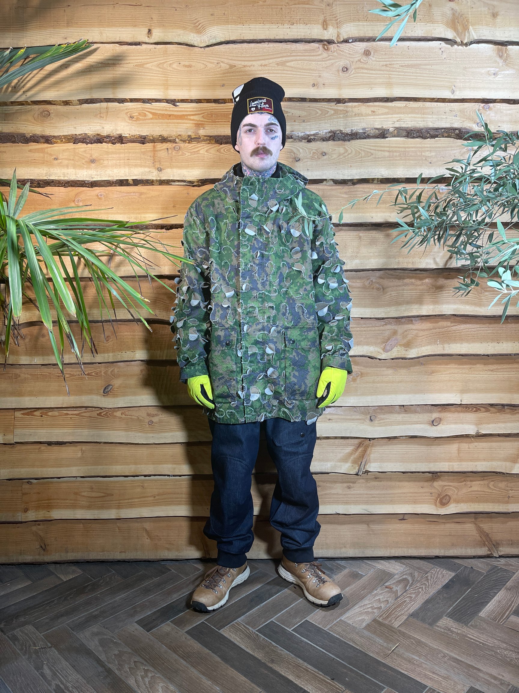 グリーンのジャケットと帽子を被る男性