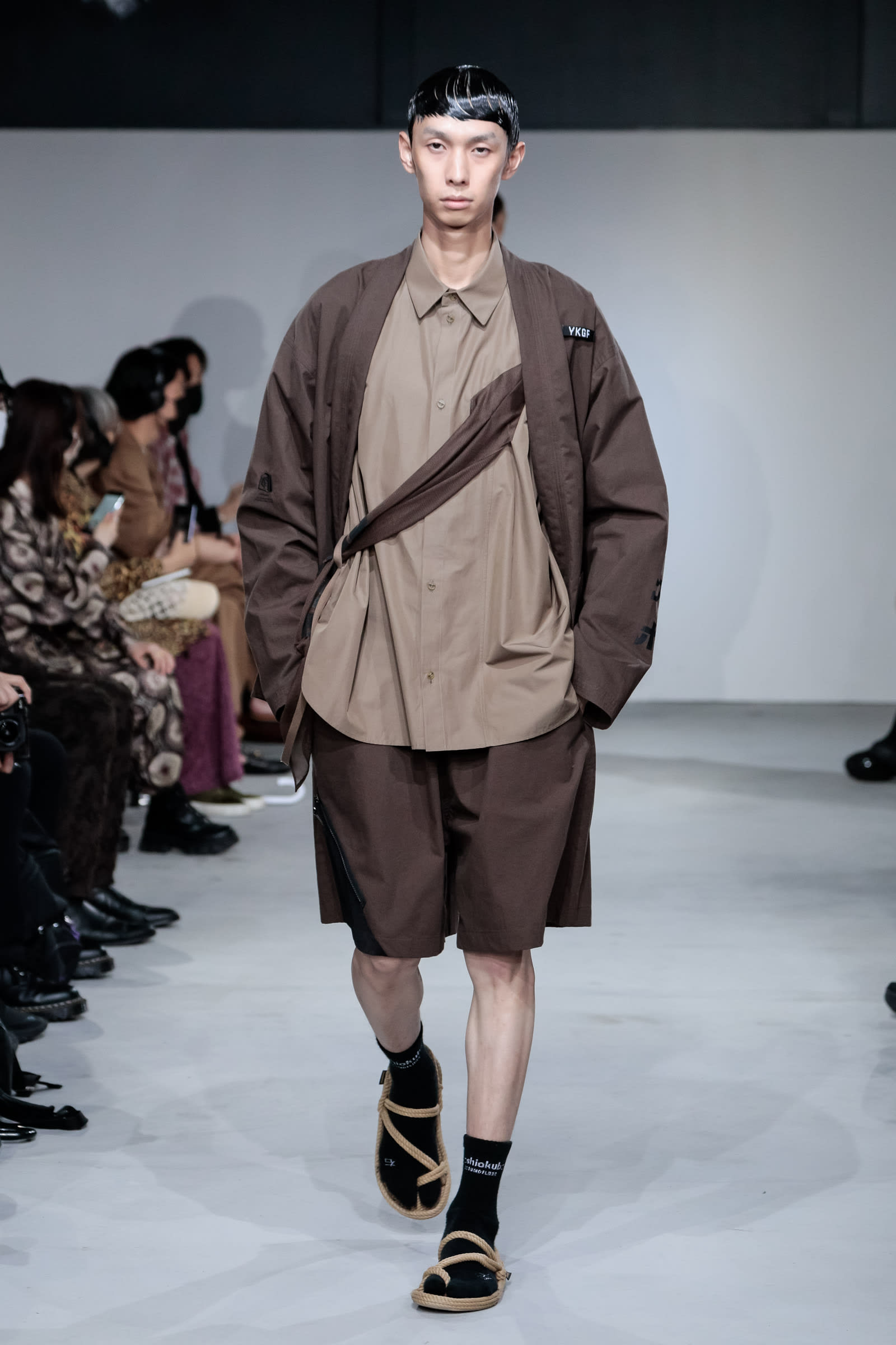 ヨシオクボのスカーフシャツを着用した男性モデル