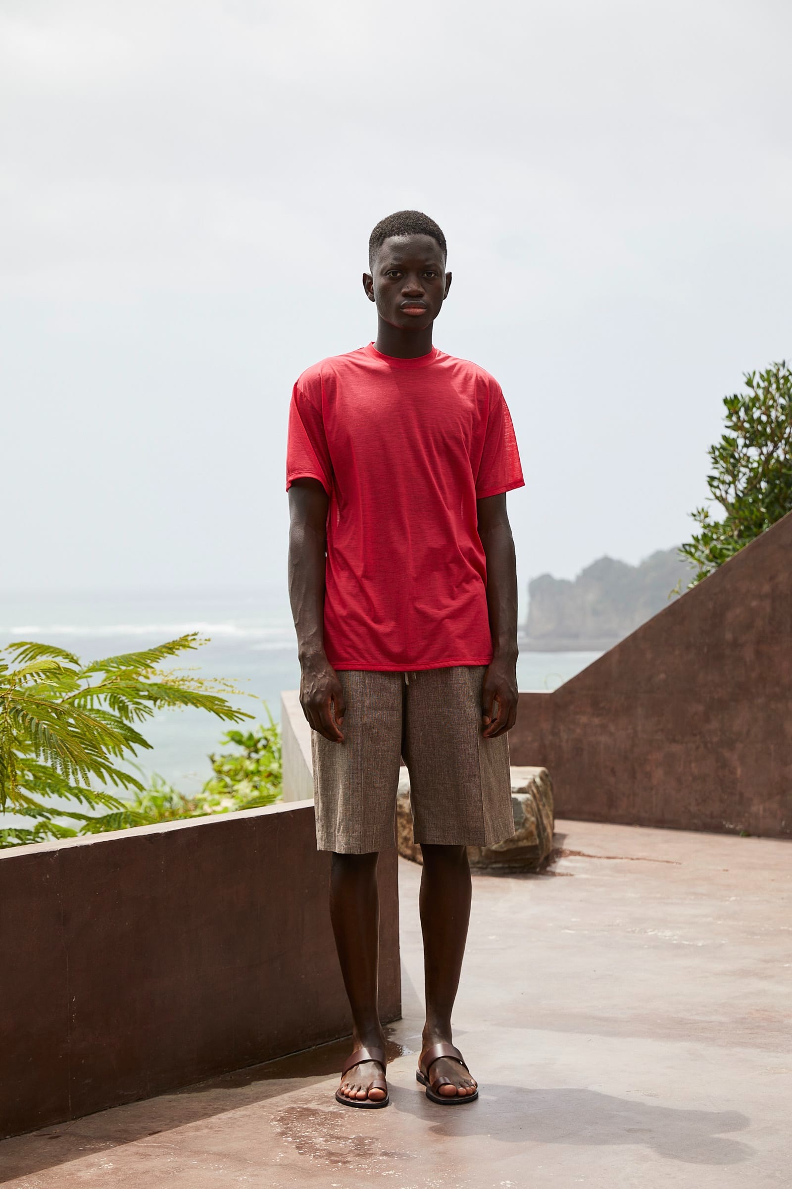 赤いTシャツとハーフパンツを着た男性モデル