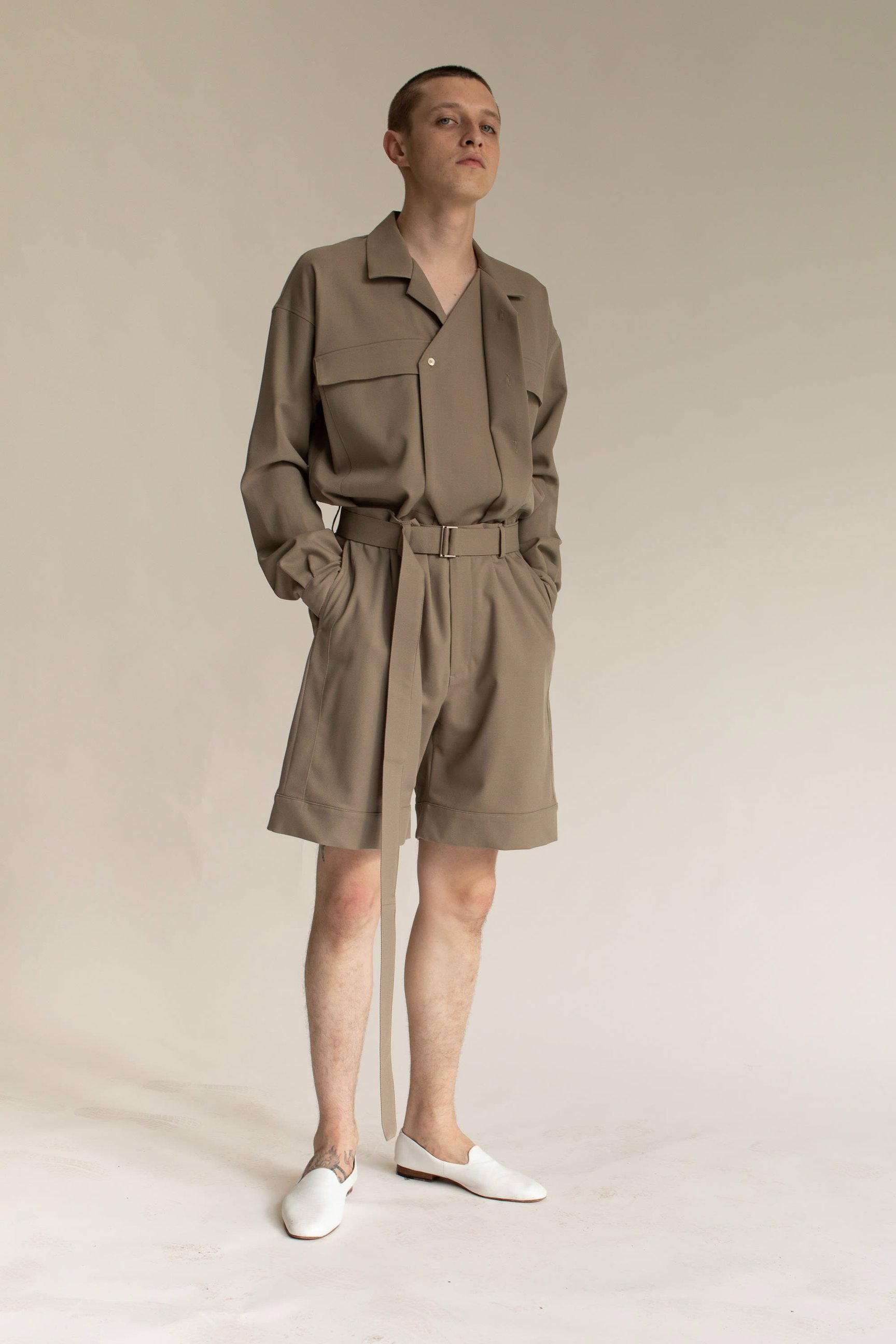 ベージュのセットアップを着た男性モデル