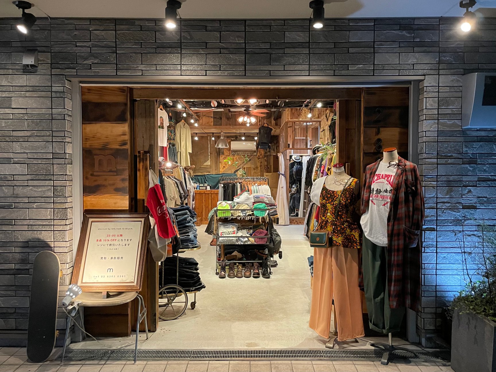 服が並んでいる古着屋「m」の夜の外観