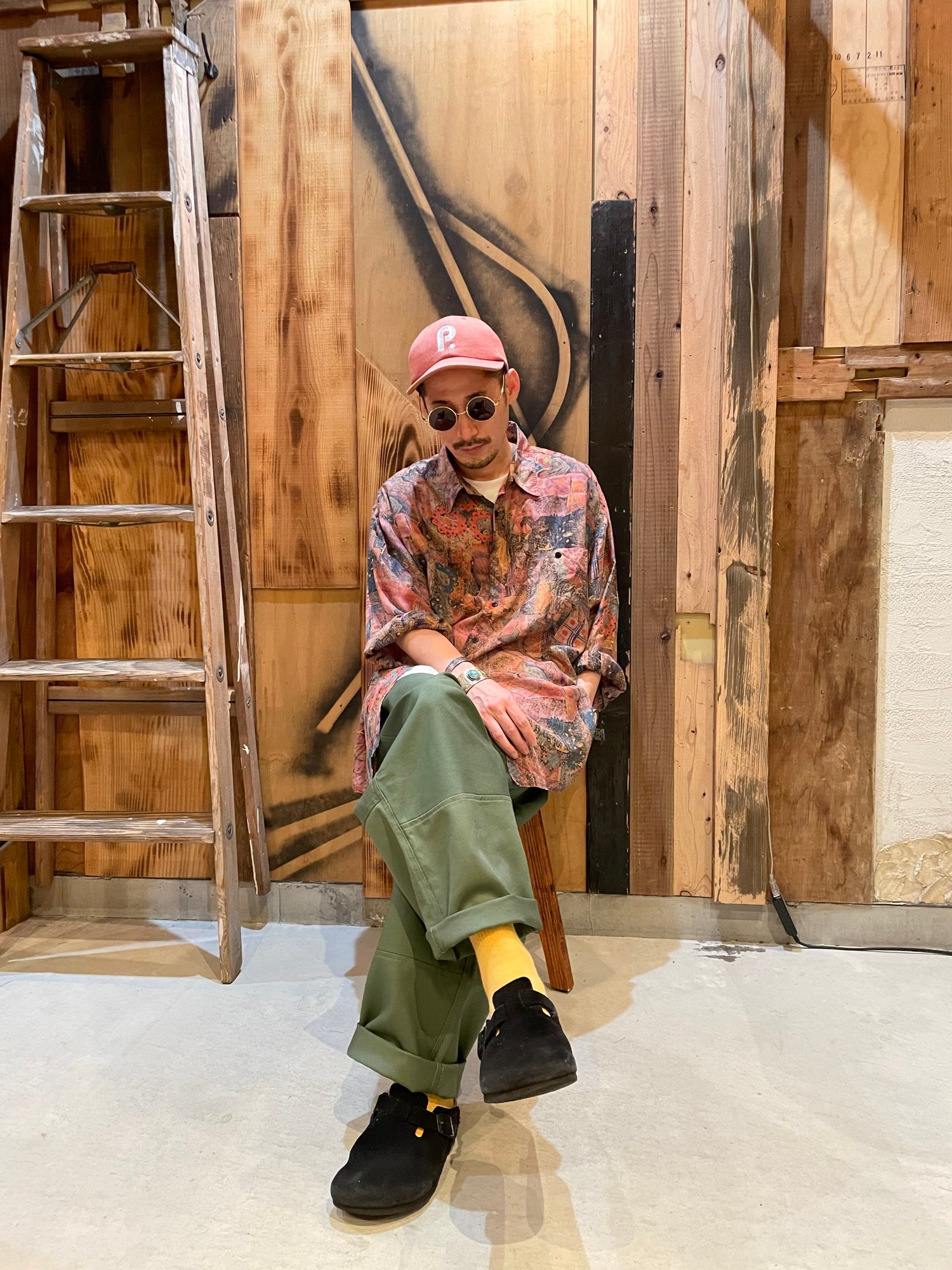 足を組んで椅子に座る古着屋「m」の店主