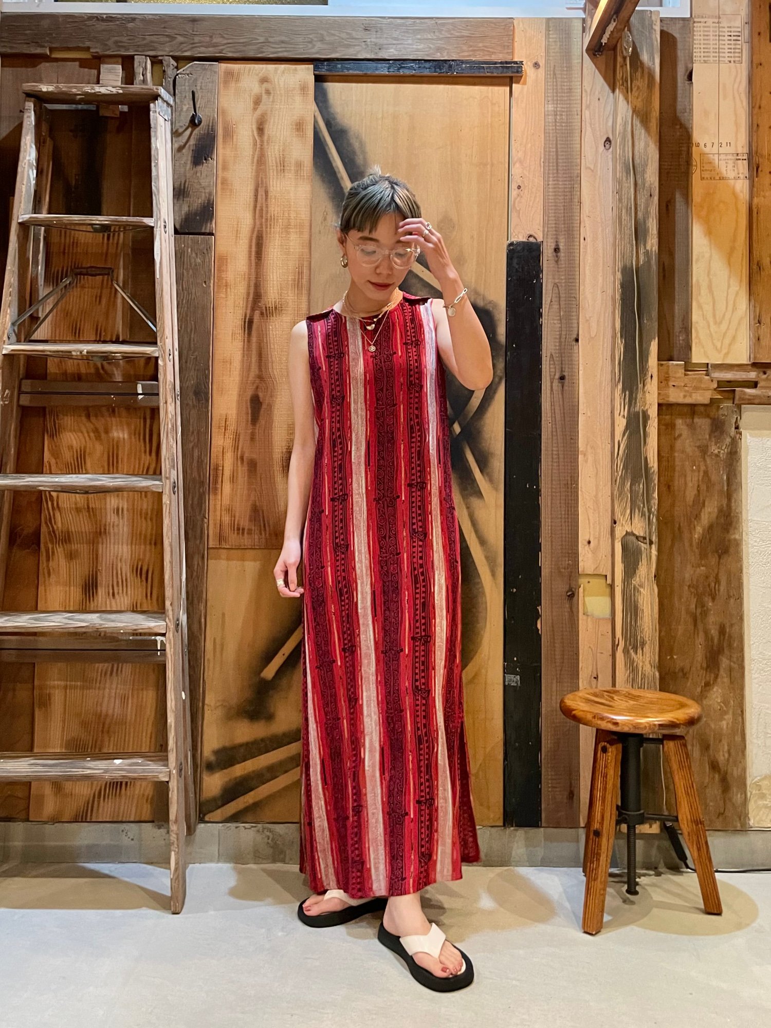 赤とピンクのストライプのワンピースを着た古着屋「m」の女性店員