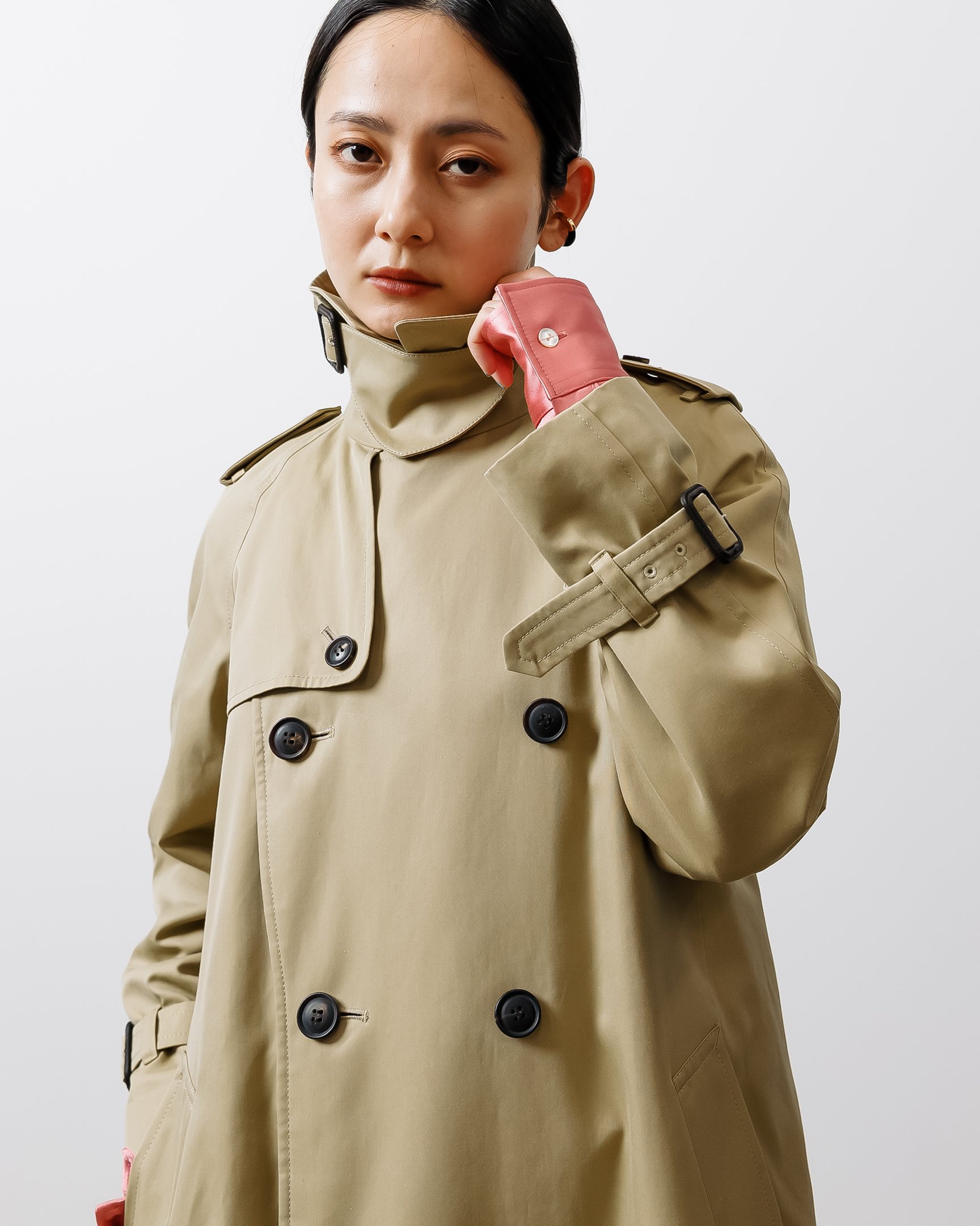 チンウォーマーつきのトレンチコートを着用した女性モデル