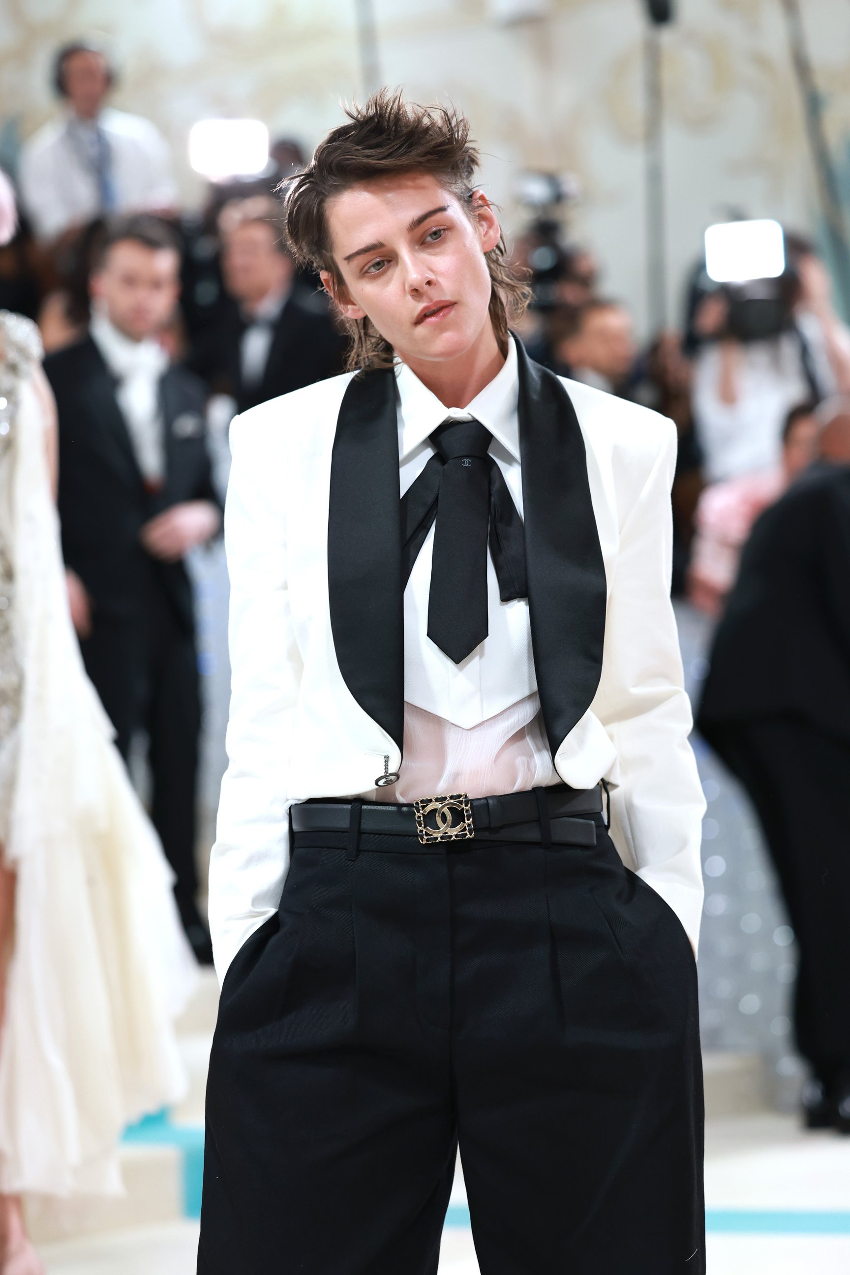 白いジャケットと黒いパンツを着用したクリステン・スチュワート