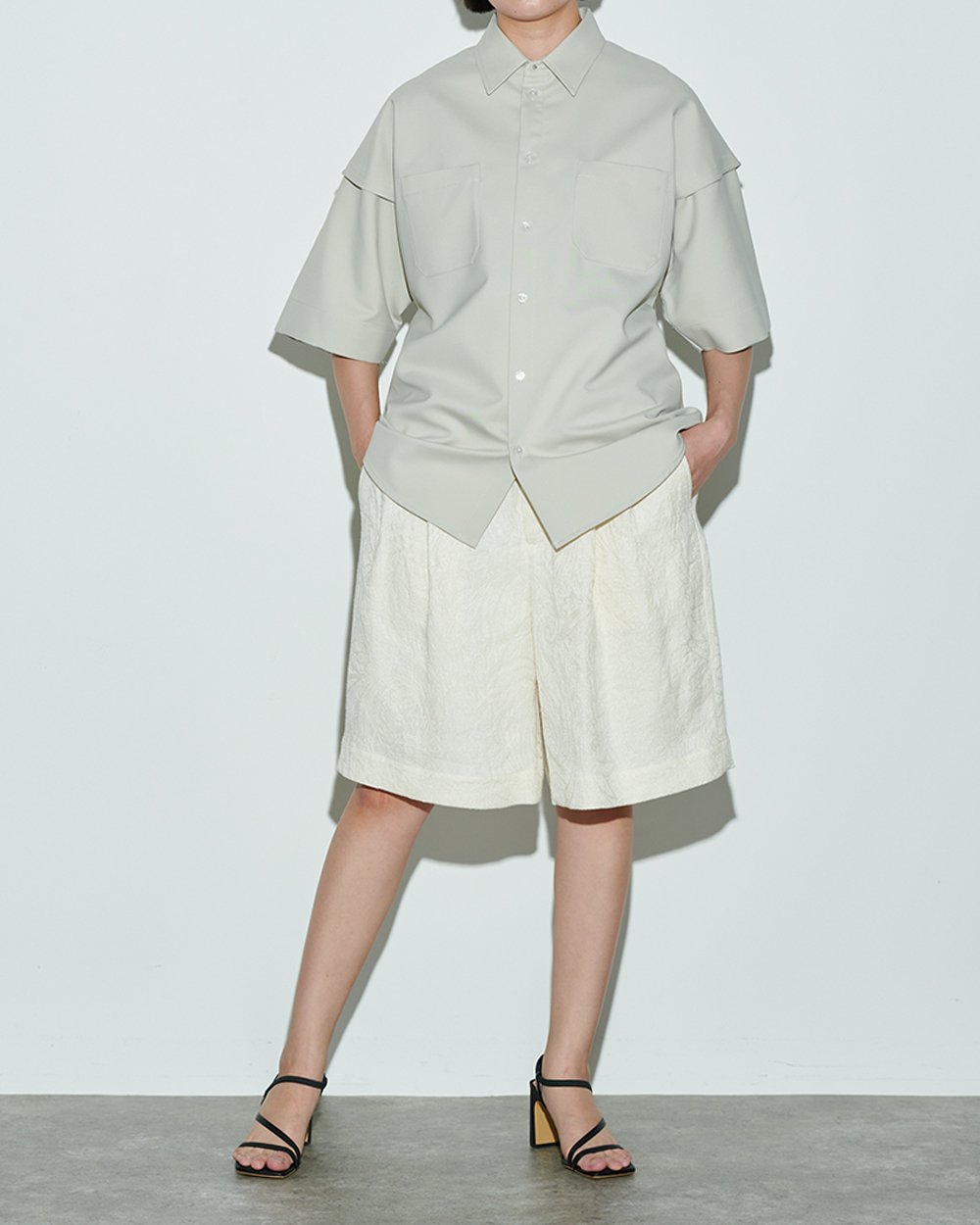 グレージュのワークシャツを着用した女性モデル