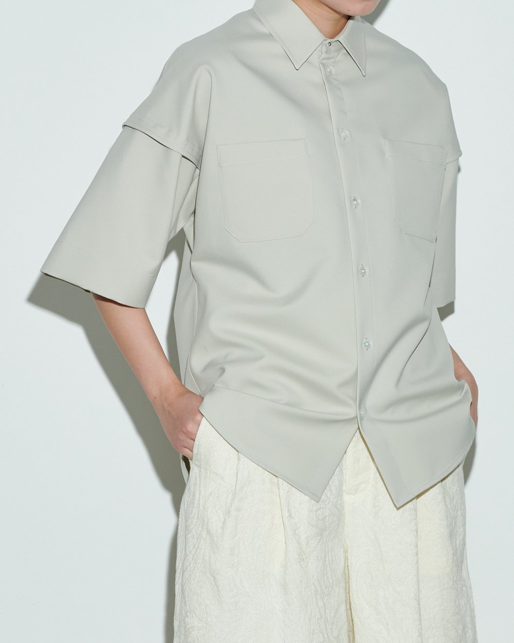 グレージュのワークシャツを着用した女性モデル