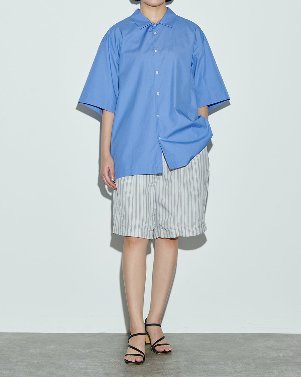 ブルーのコットンシャツを着用した女性モデル