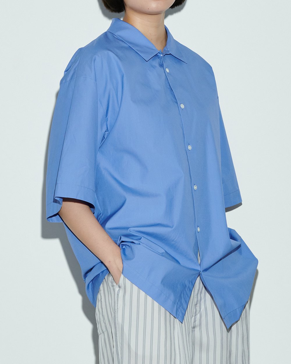 ブルーのコットンシャツを着用した女性モデル