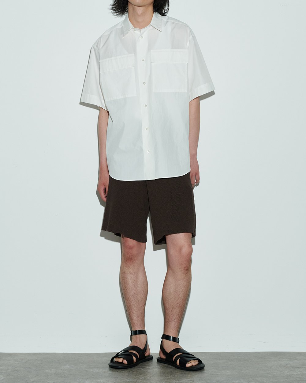 ホワイトのショートスリーブシャツを着用した男性モデル