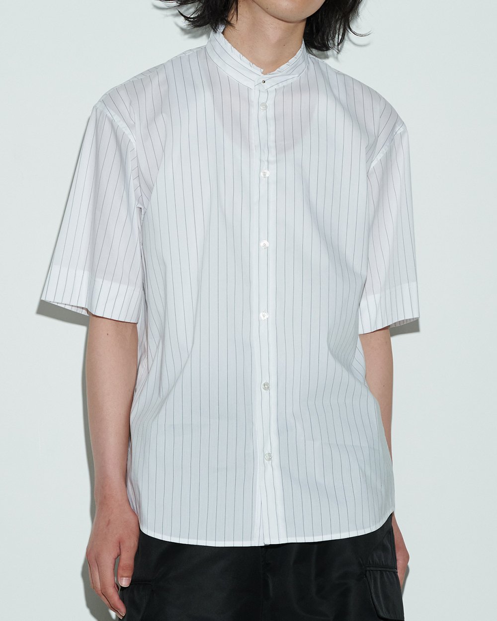 ホワイトストライプのシャツを着用した男性モデル