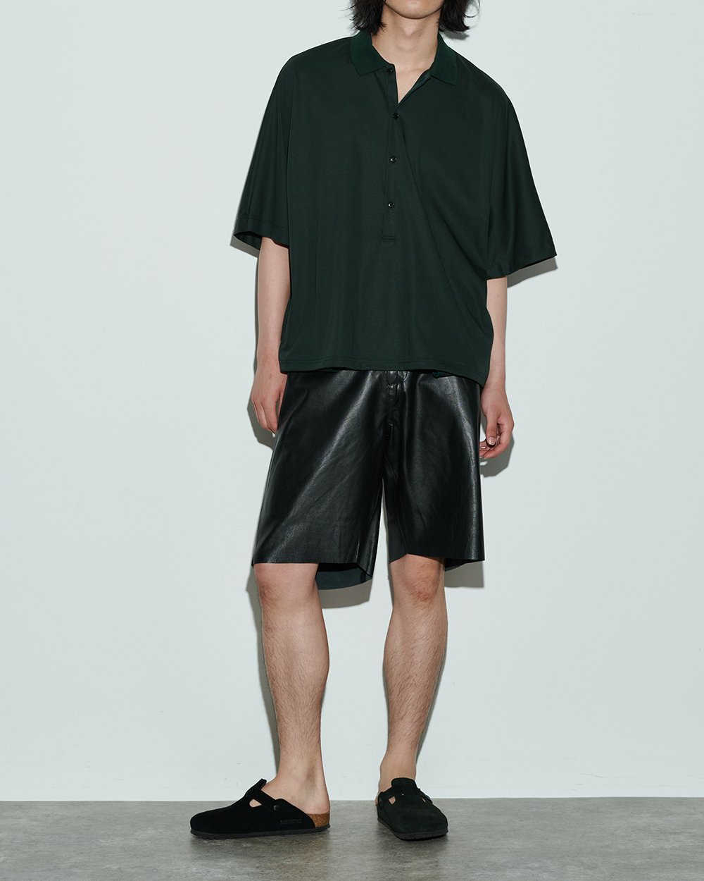 グリーンのオーバーサイズポロシャツを着用した男性モデル