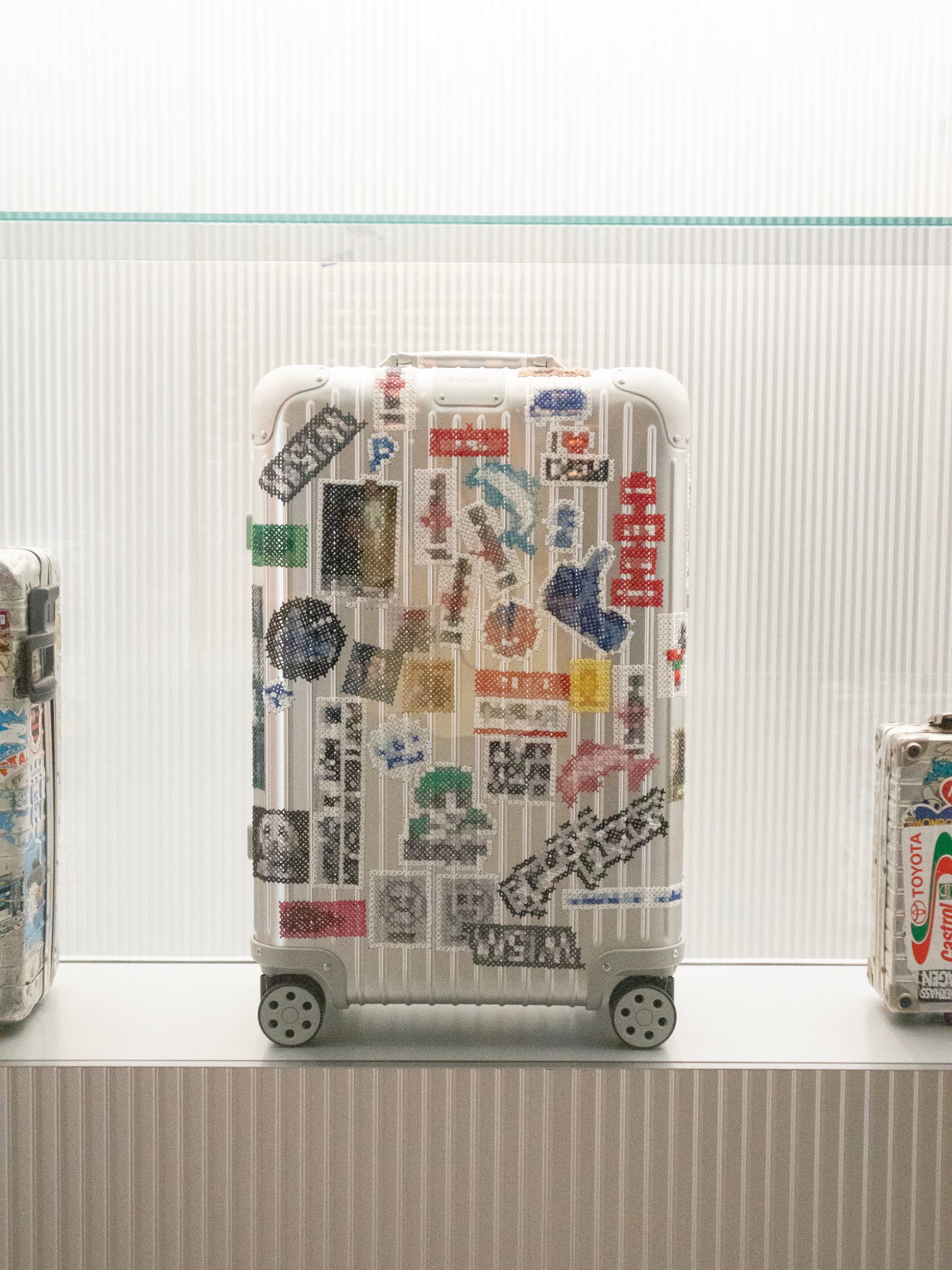 ステッカーに見立てた刺繍を施したスーツケース