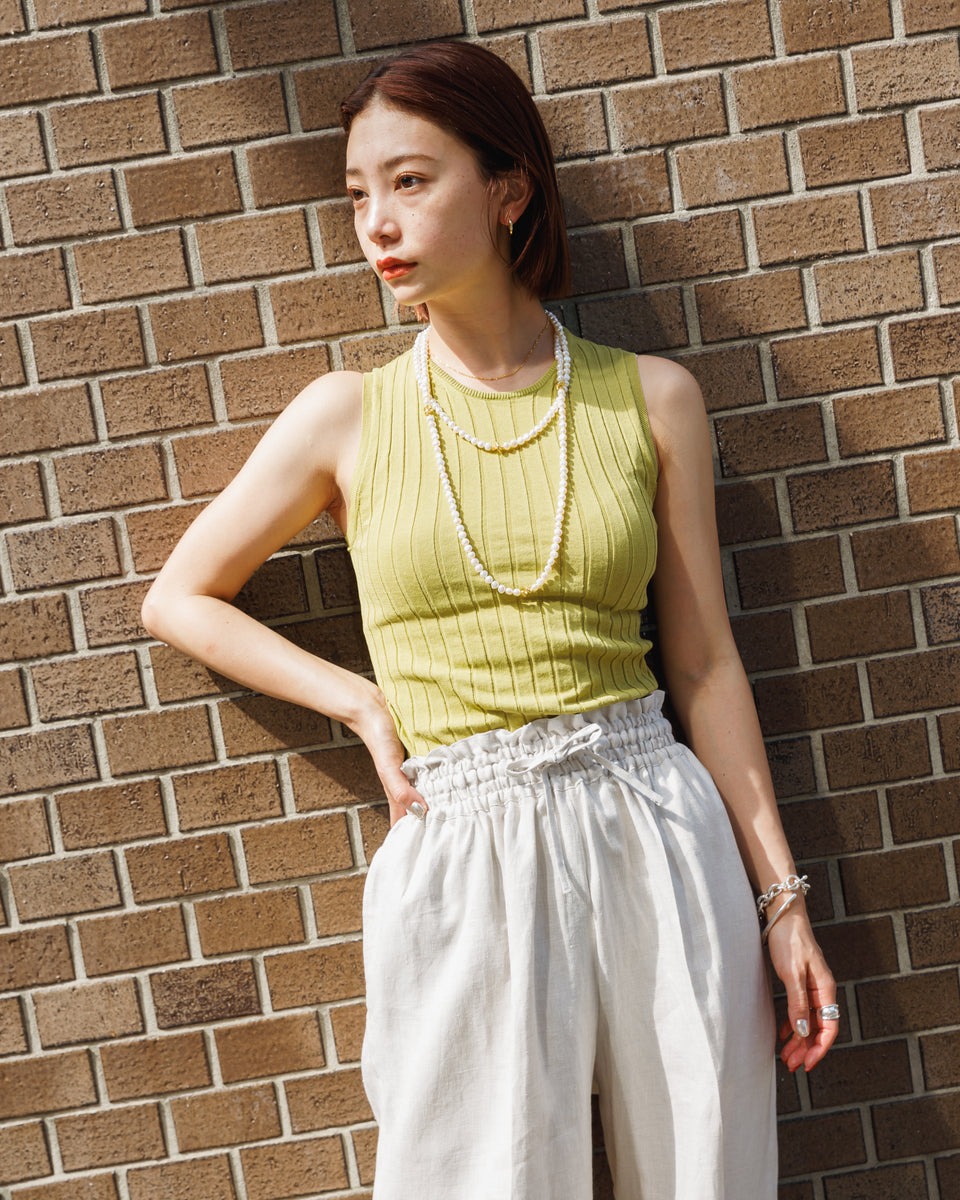 女性のスナップ画像。リネンシルクのハーフパンツにパールのネックレスのスタイリング。