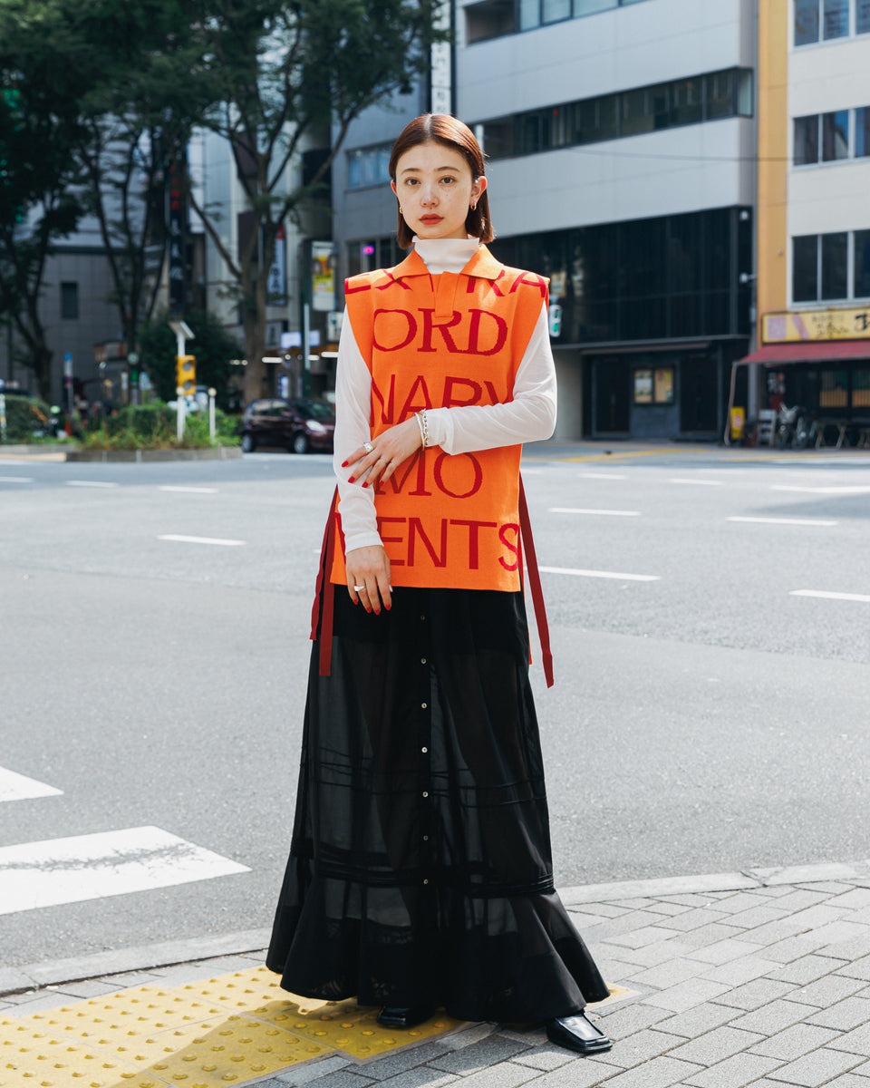 女性のスナップ画像。ブラックのフレアスカートとのスタイリング。