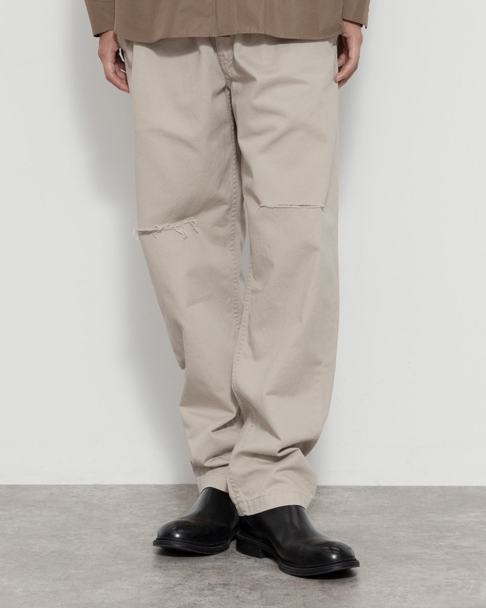 ダメージの入ったチノパンツを着用している男性モデル