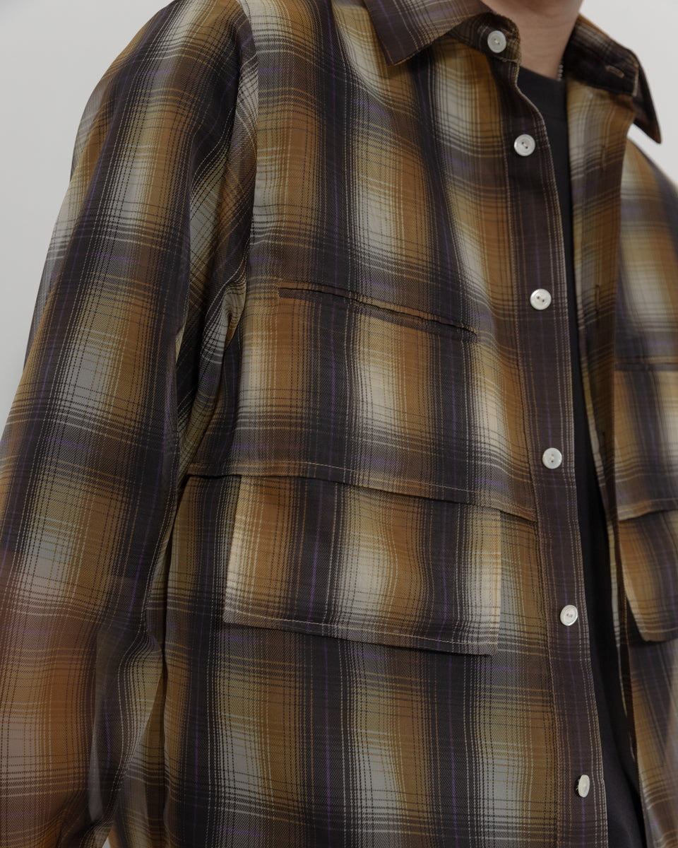 男性の着用画像。ブラックのTシャツとのレイヤードスタイル。