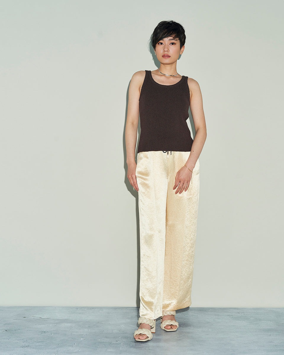 女性の着用画像。ゴールドのパンツ、ネックレスとのスタイリング。