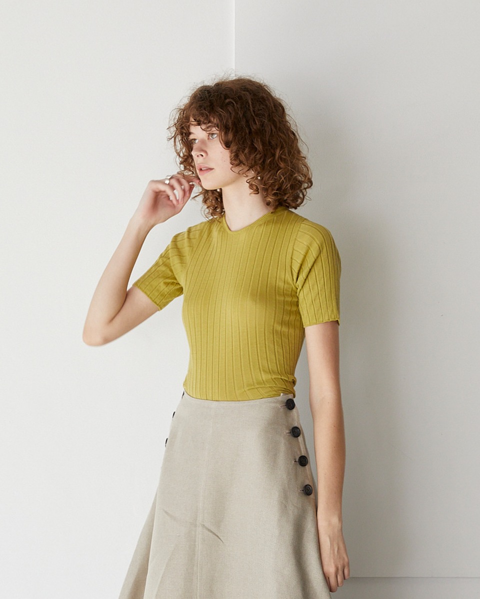 女性のルック画像。グレーのスカートとのスタイリング。