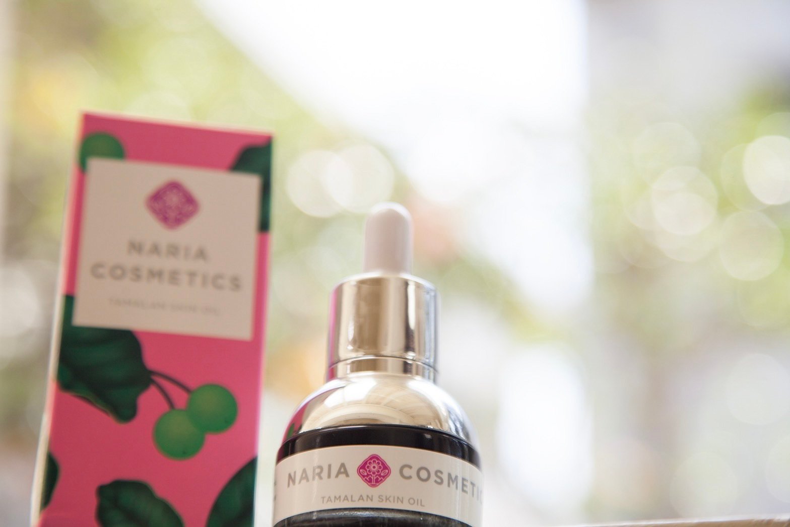 窓際に美容液とピンクの外箱が並ぶ写真