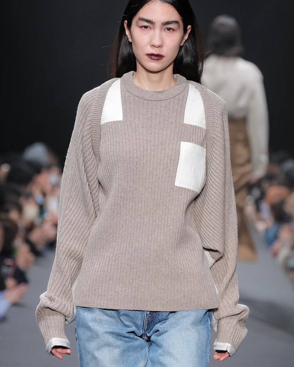 女性のルック画像。ボレロにデニムとロングブーツのスタイリング。