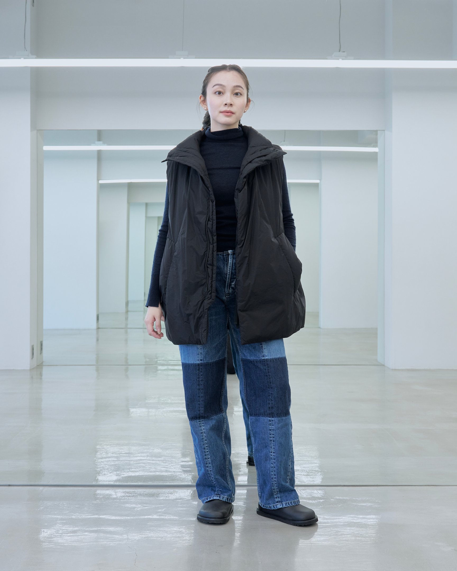 テアトラのダウンベスト「ミュートスコープ ベスト」を着用した女性モデル