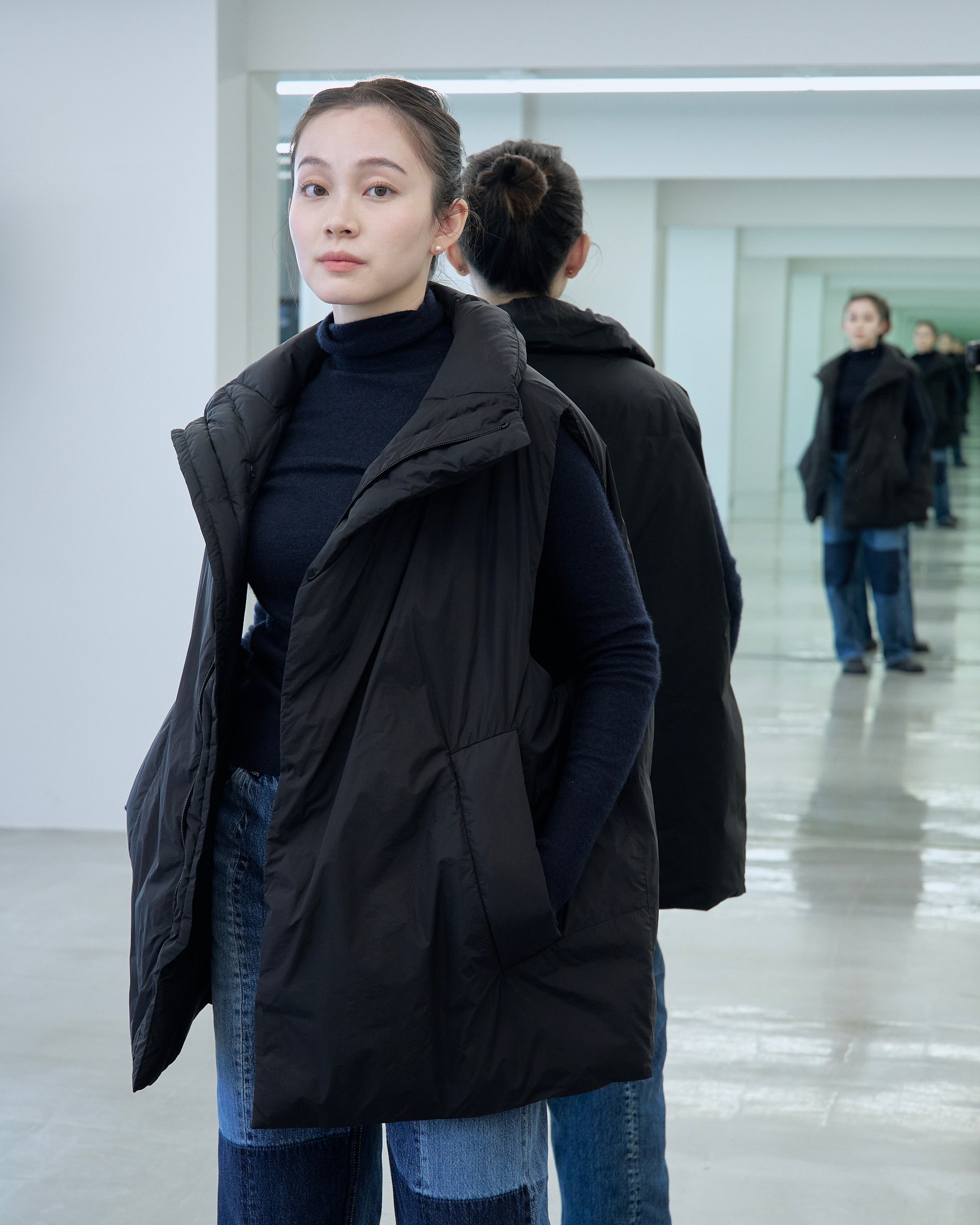 テアトラのダウンベスト「ミュートスコープ ベスト」を着用した女性モデル