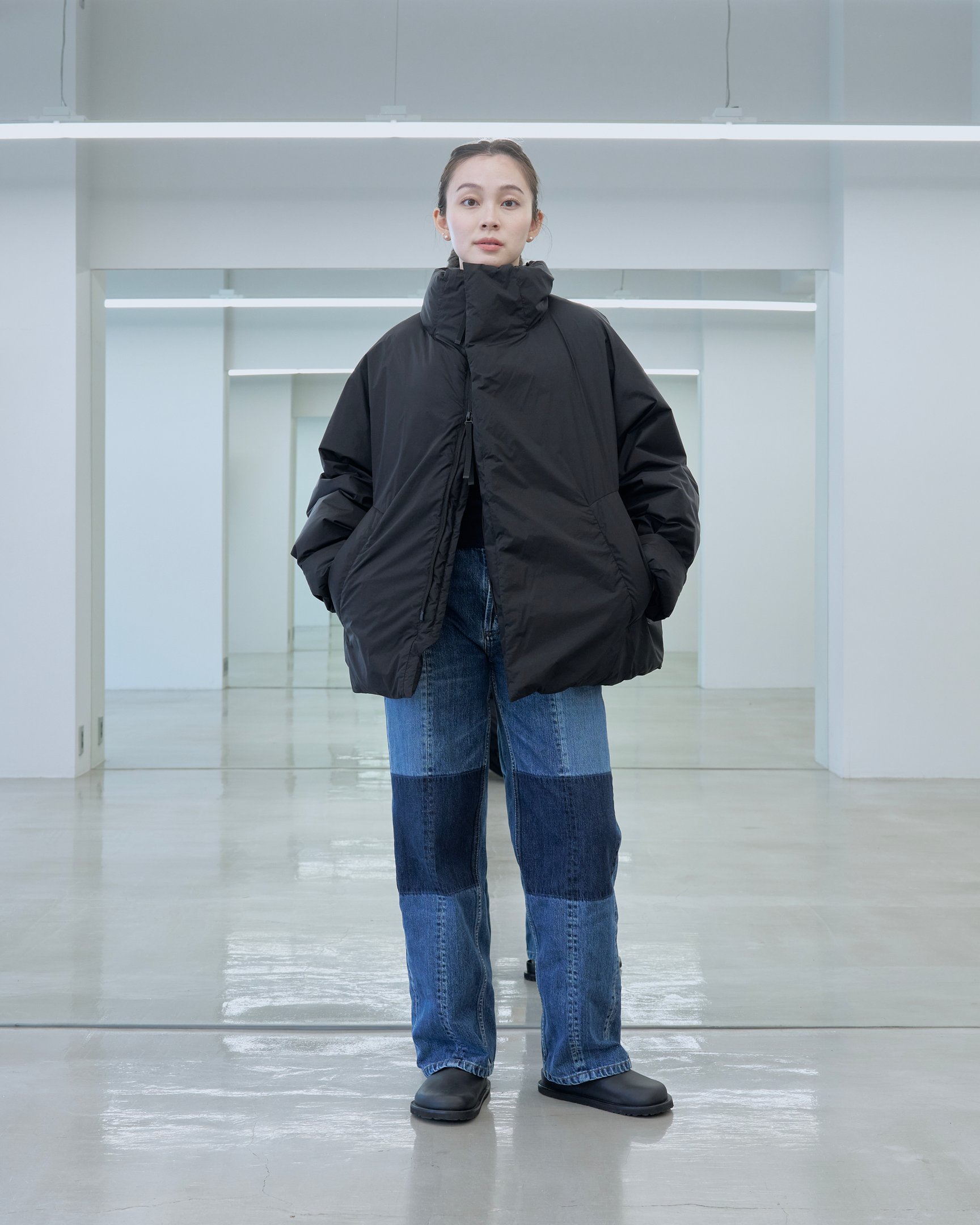 テアトラのダウンアウター「ミュート スコープ」を着用した女性モデル