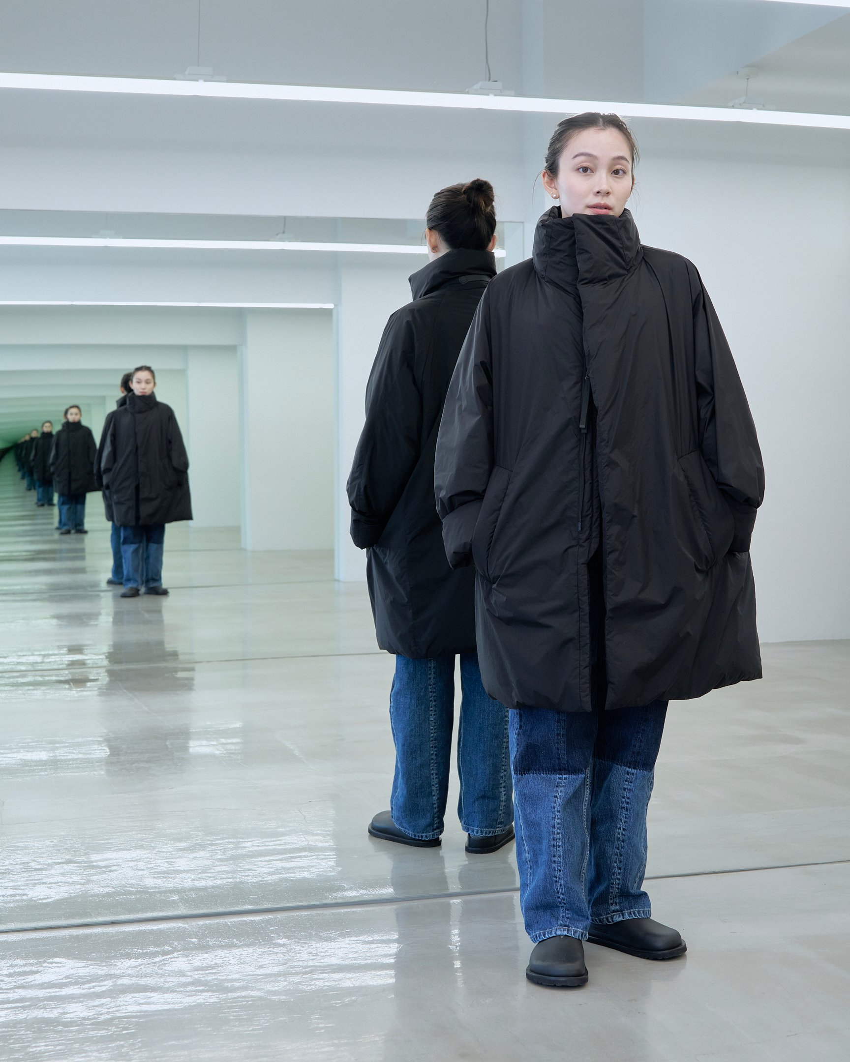 テアトラのダウンアウター「ミュート スコープ」を着用した女性モデル