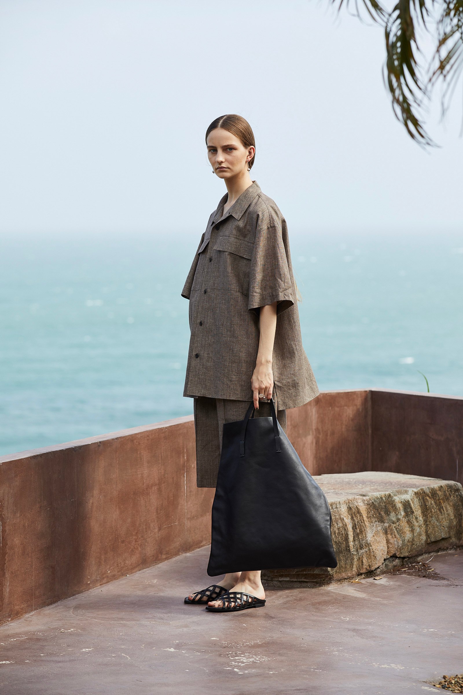 ポステレガントのブラウンのシャツとハーフパンツを着用した女性モデル